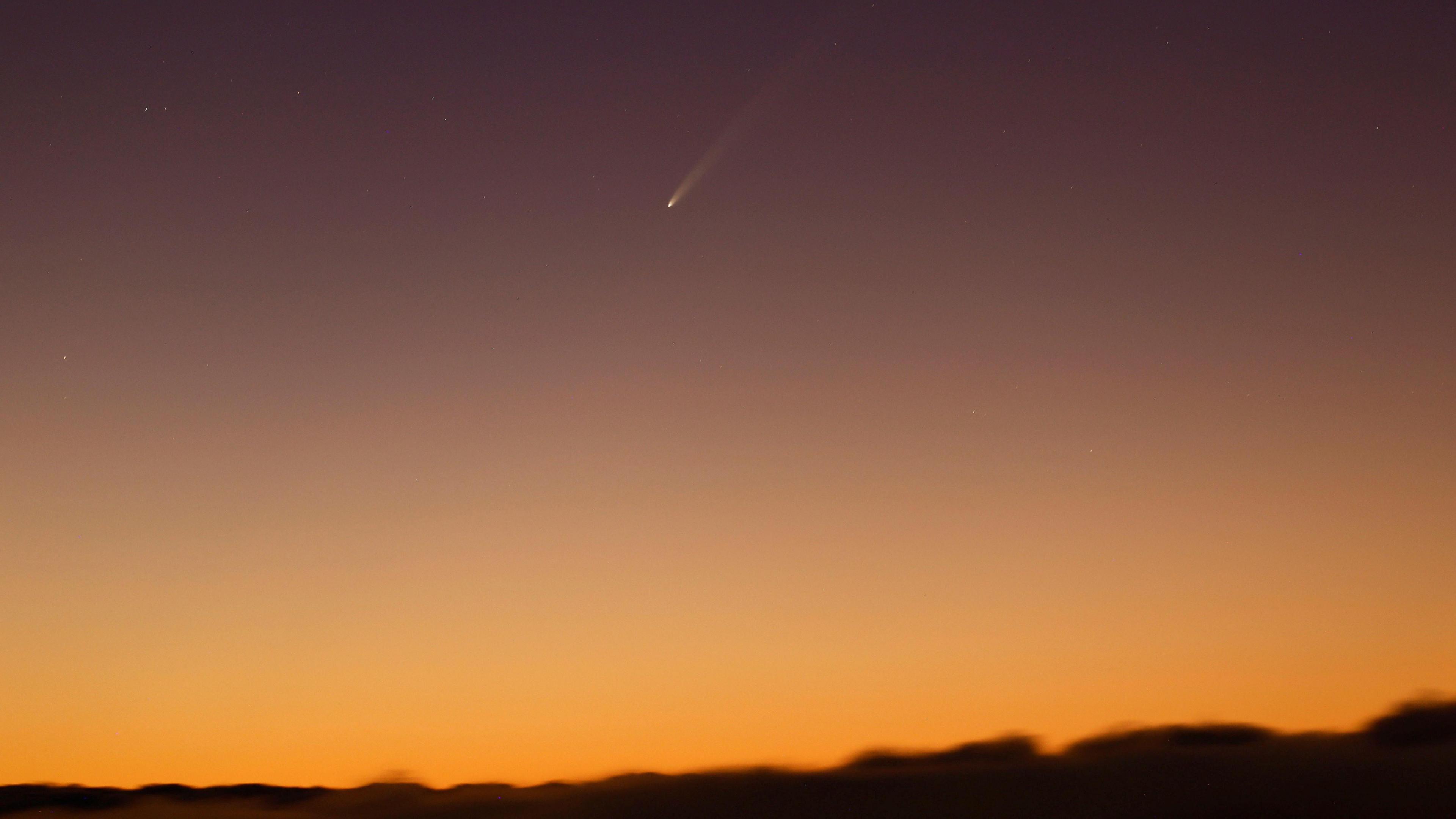 Orange sky and comet above land in Gran Canaria.