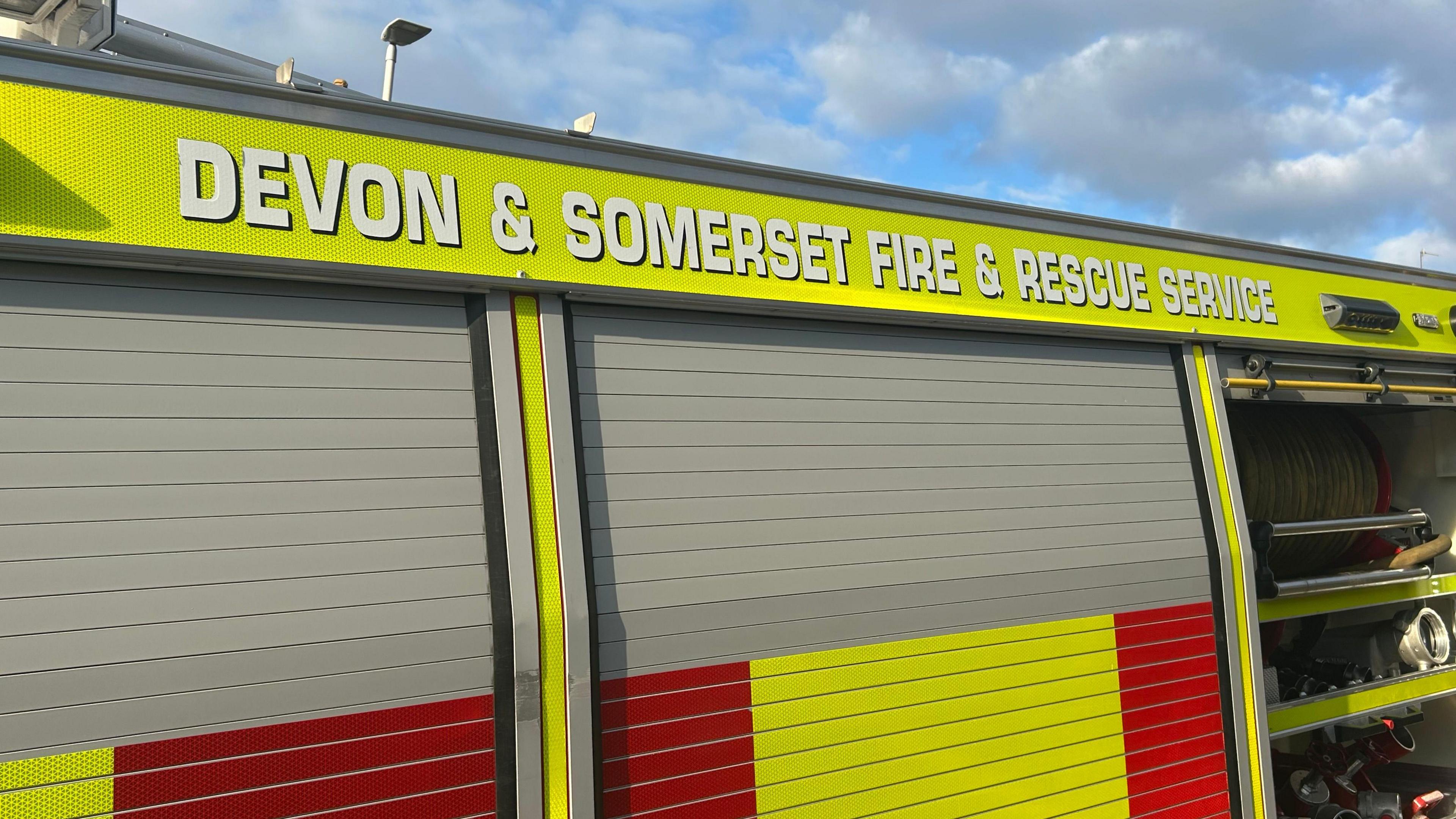 A picture of the side of a Devon and Somerset fire vehicle. It is red and green in colour with the force name at the top of the vehicle.