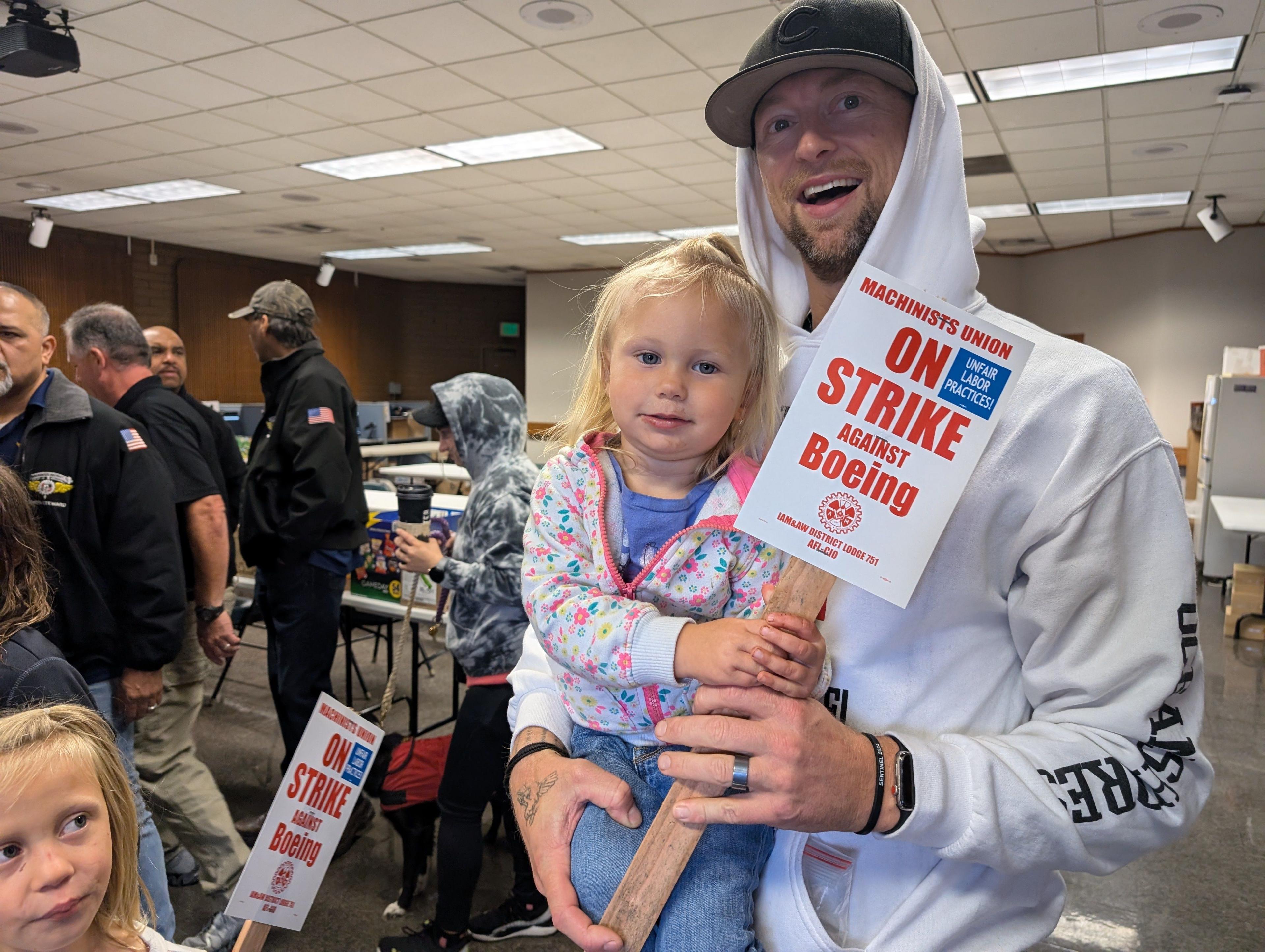 Man holding a child and a strike sign