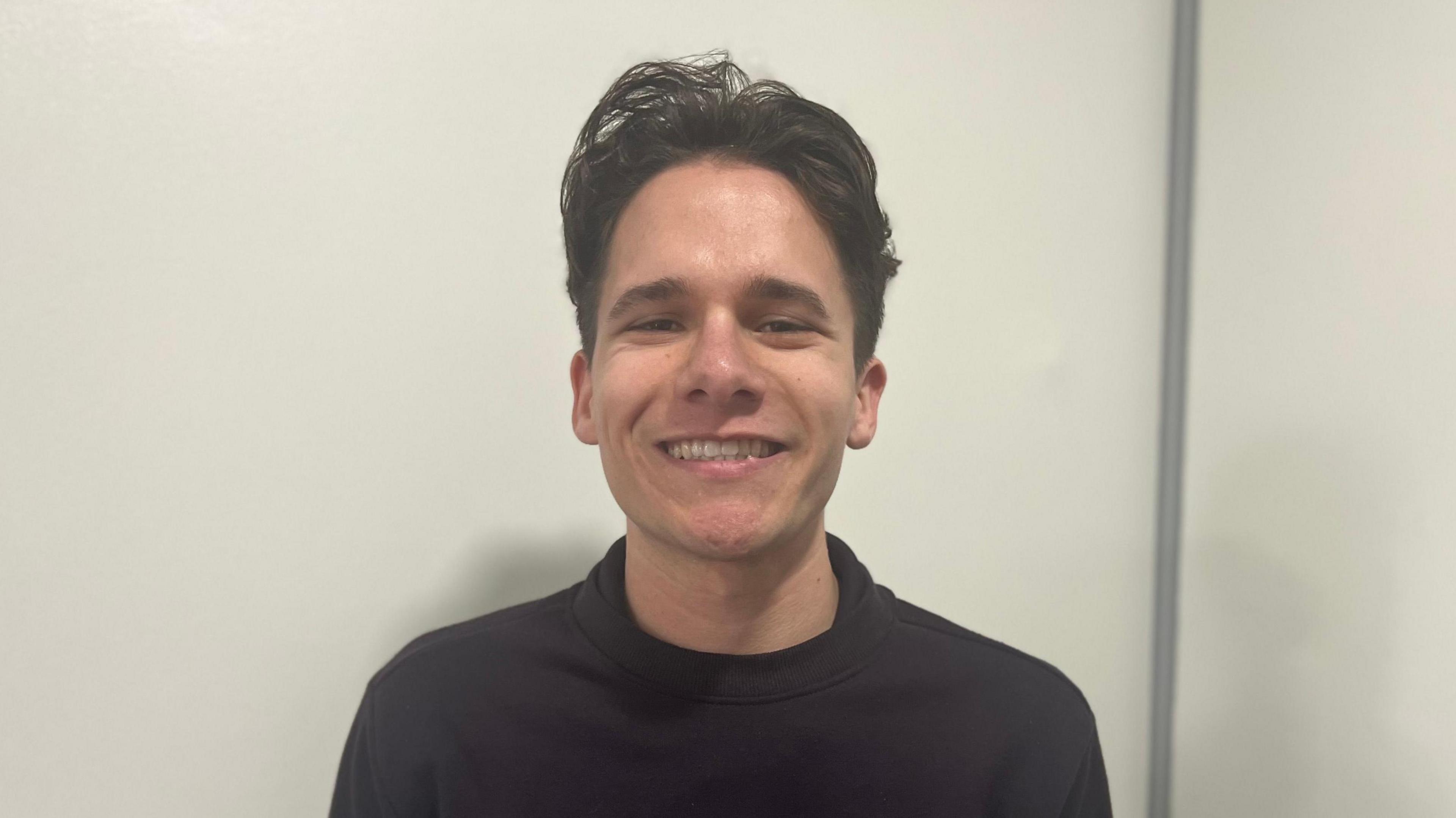 Train driver Charlie Eric Potts with short dark brown hair wearing a black sweatshirt