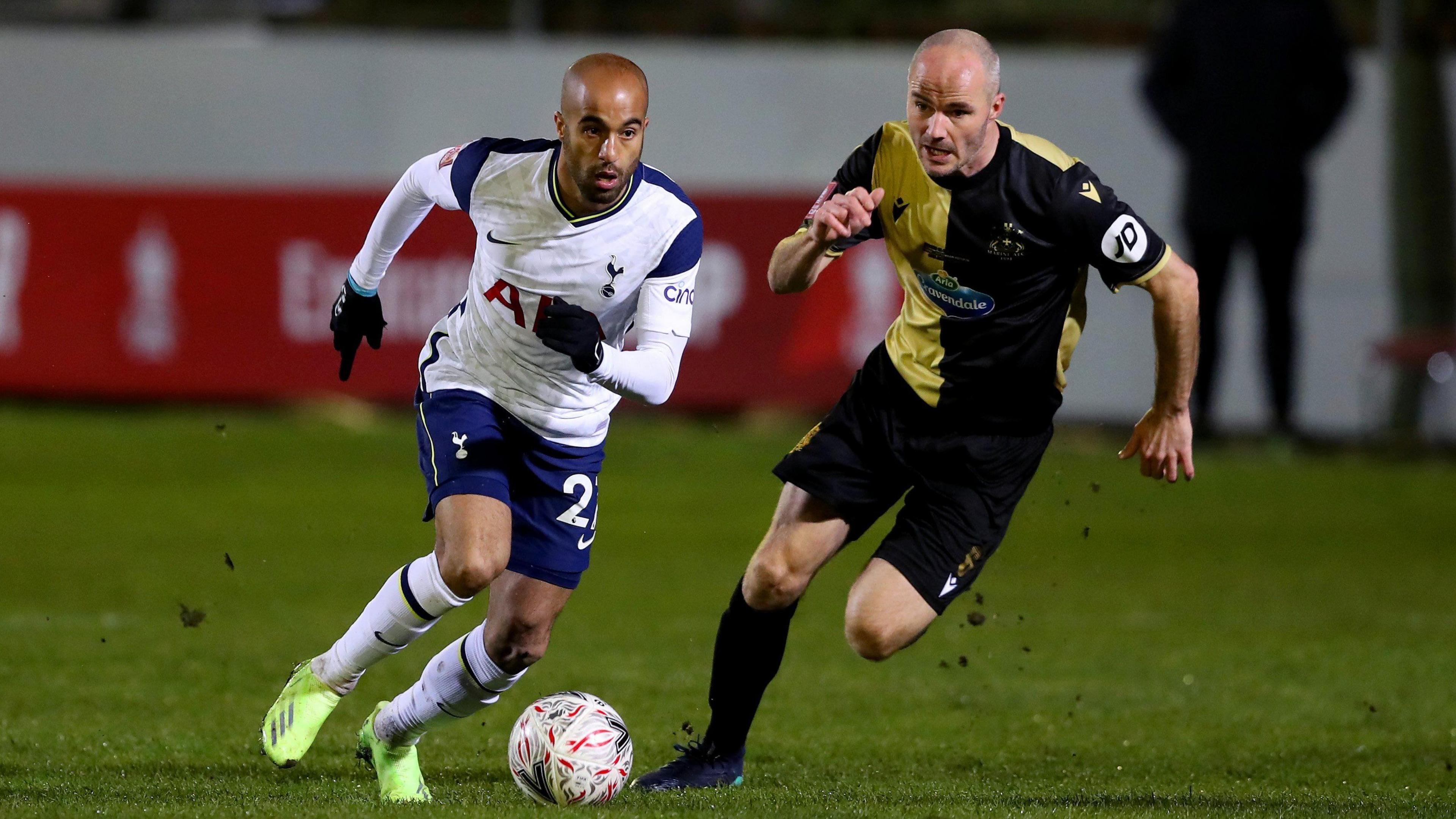 Tottenham Hotspur forward Lucas Moura (left) dribbling the ball away from Marine midfielder David Raven.