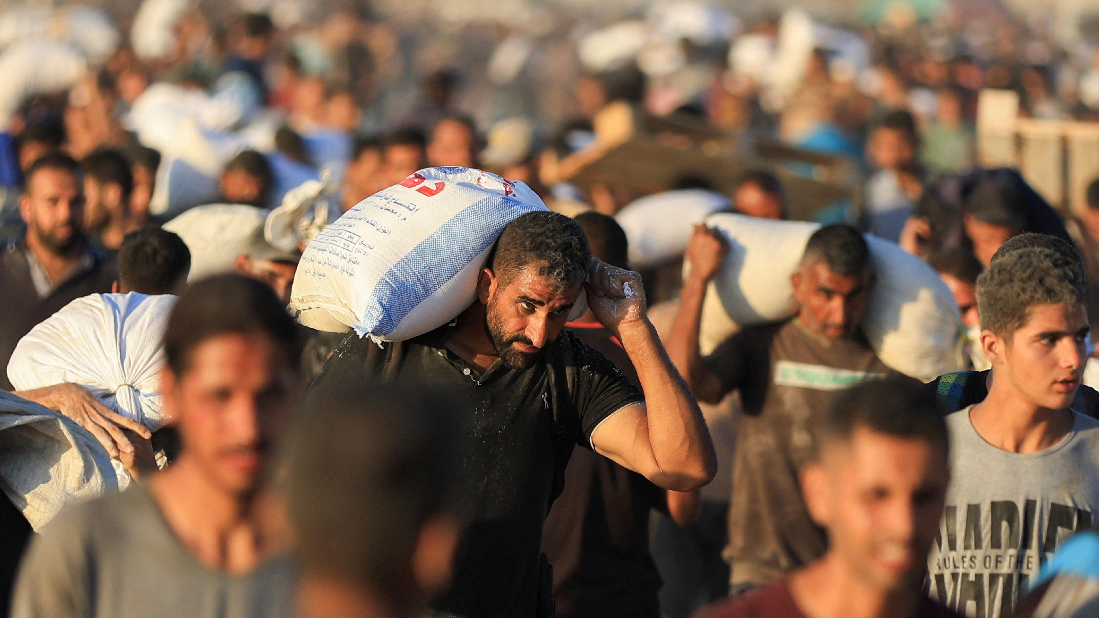 Palestinians carry aid supplies in Beit Lahia in the northern Gaza Strip