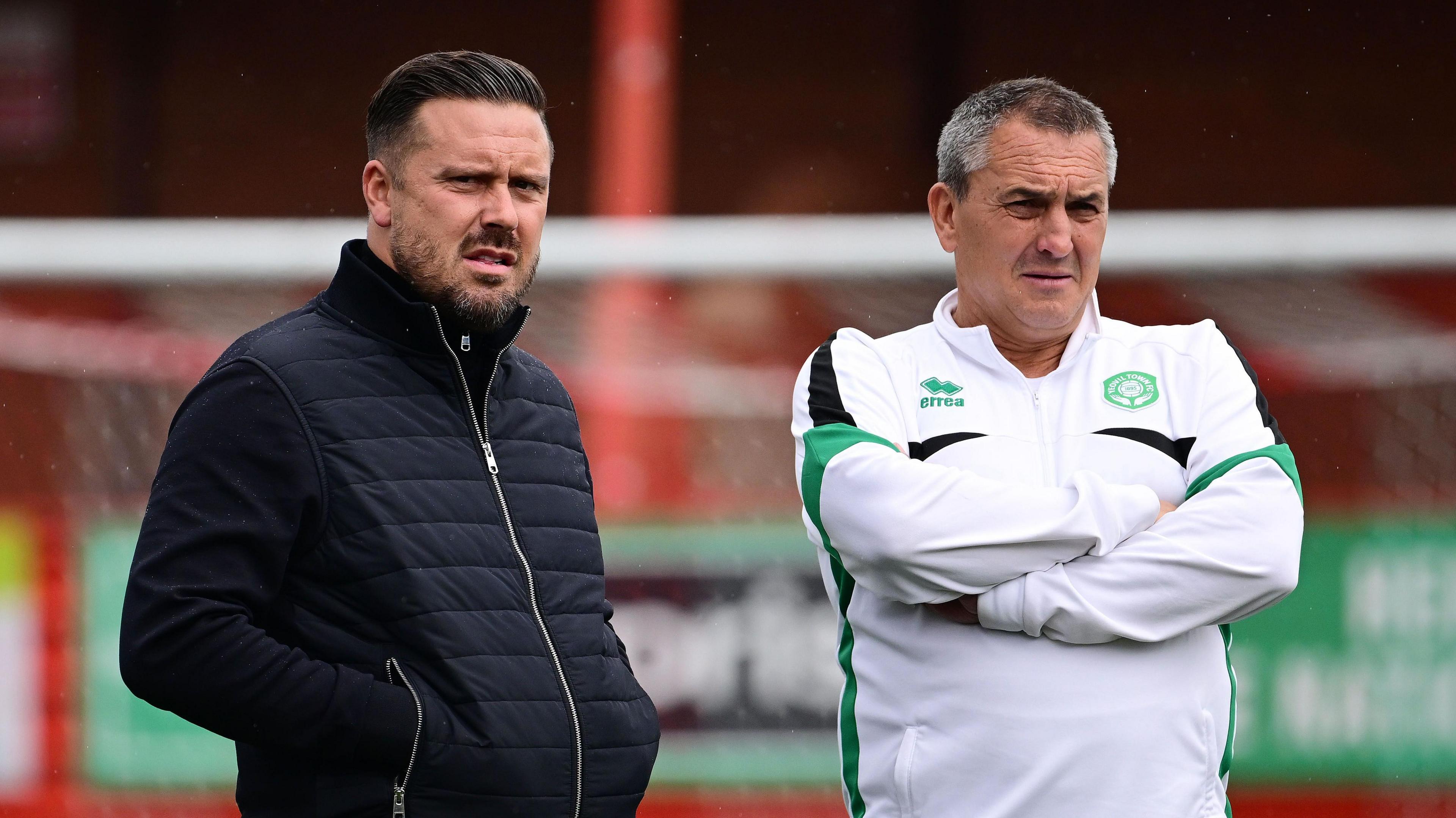 Danny Webb (left) and Richard Dryden standing watching Yeovil Town