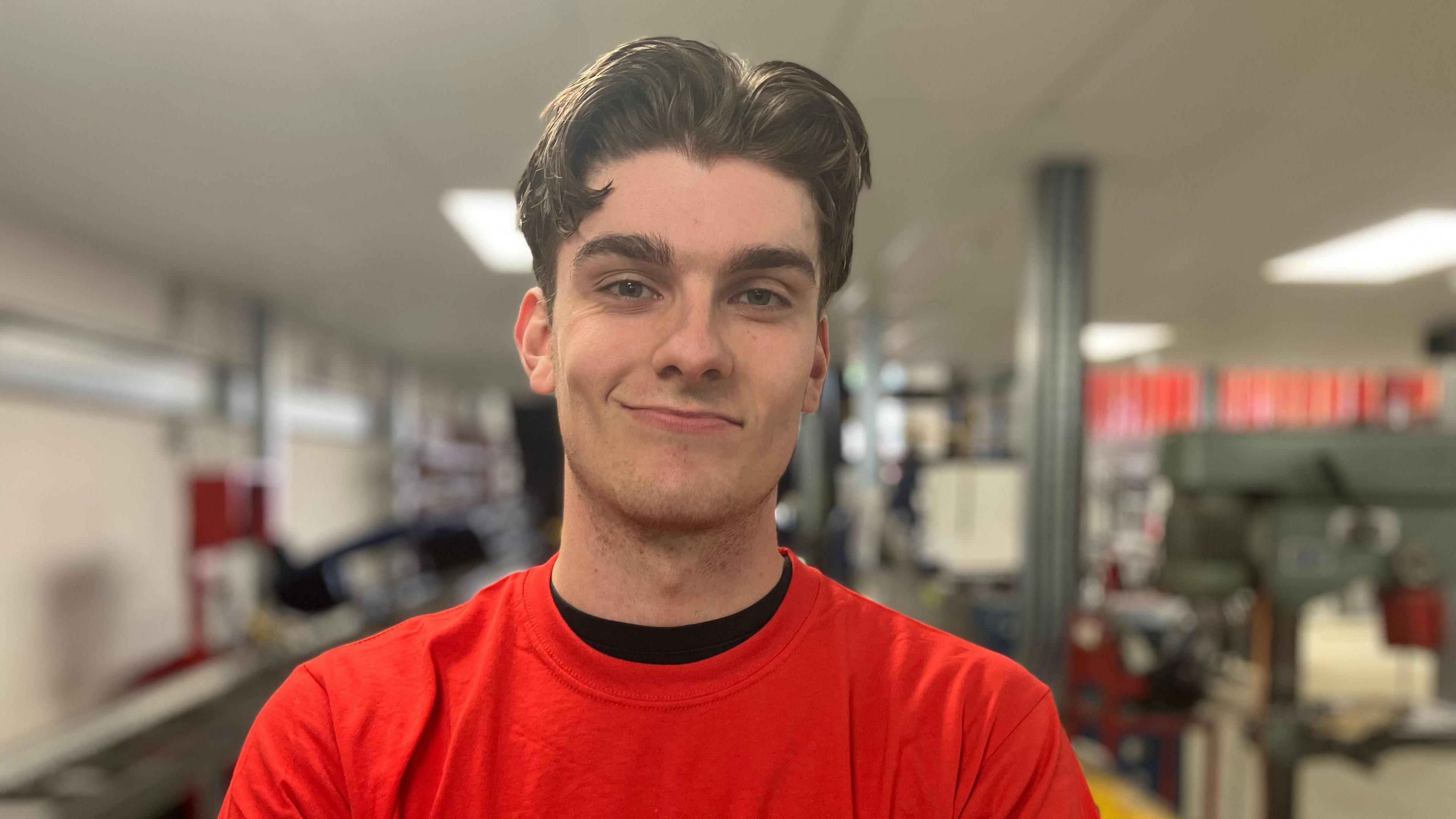 A young man wearing a Redhill Manufacturing t-shirt