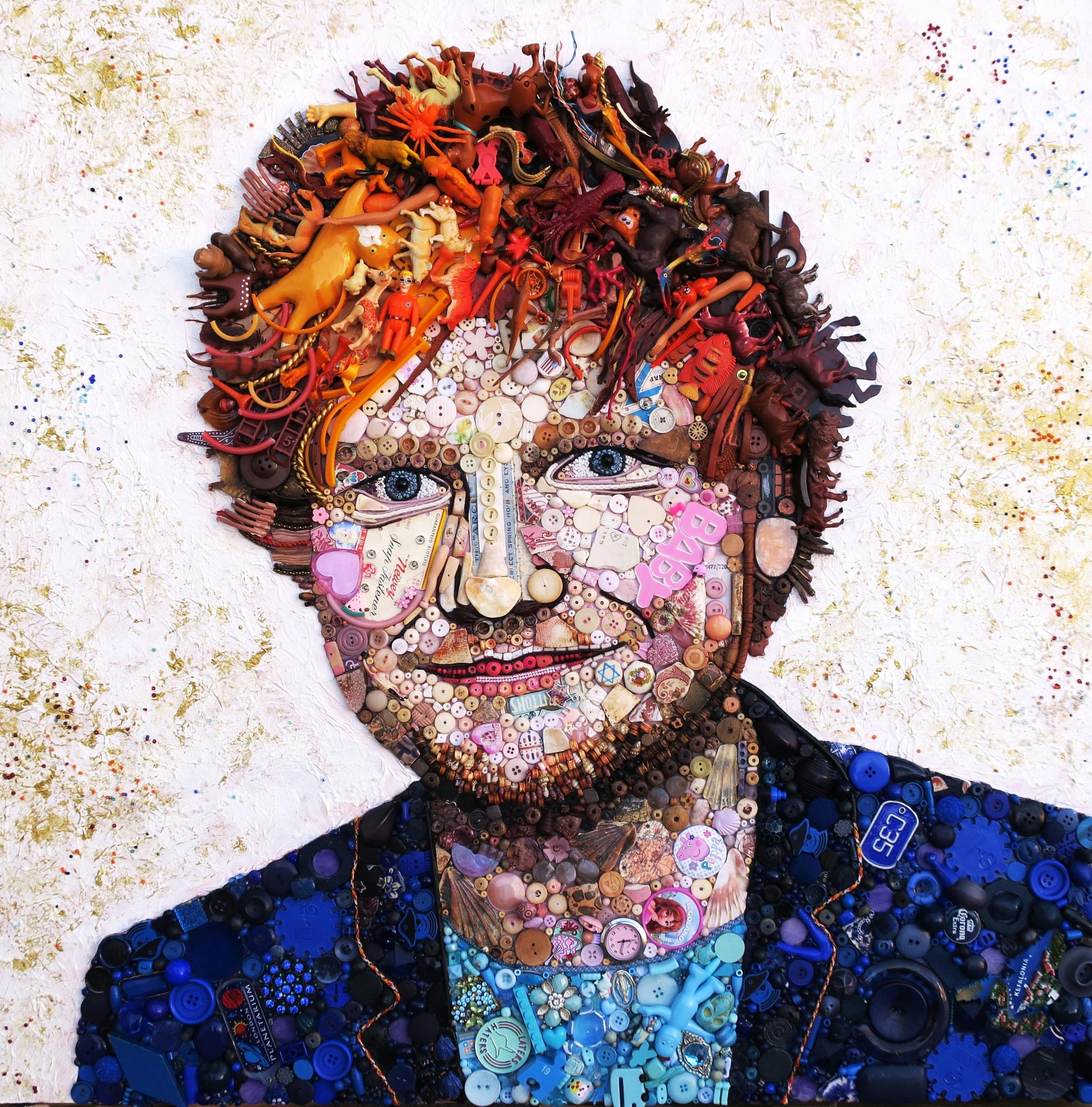 The musician Ed Sheeran wears a blue jacket and has red hair. The portrait combines plastic toys, coloured string, trinkets and buttons.