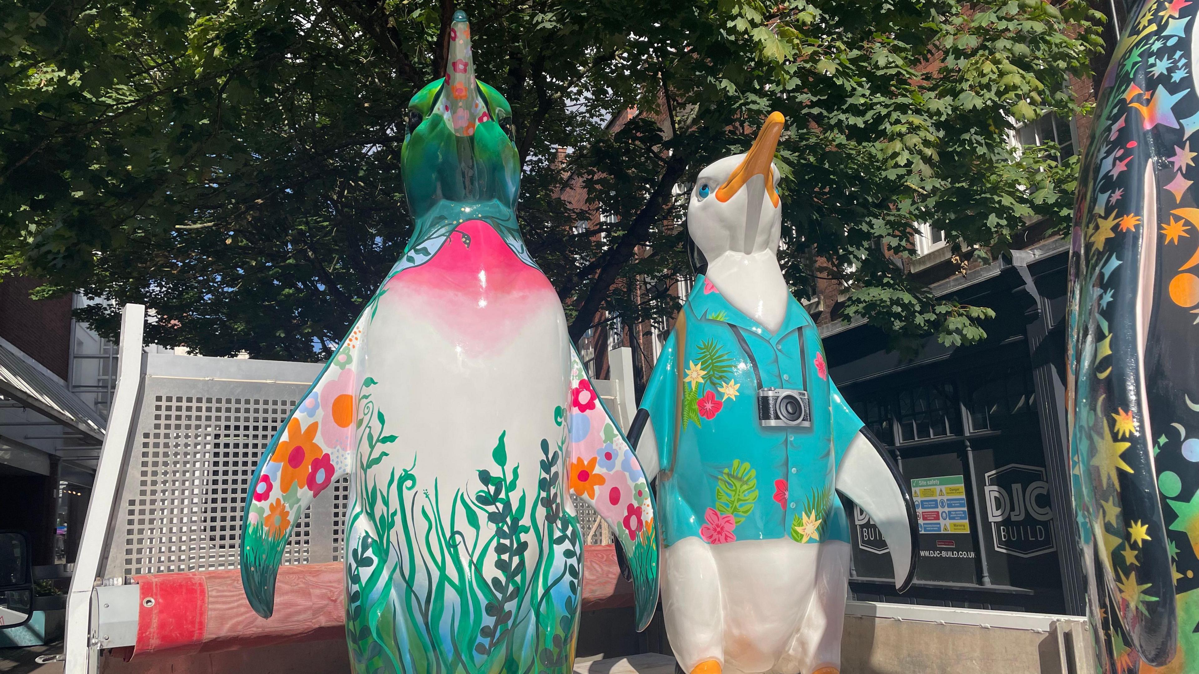 Two penguin sculptures on a truck ready to offload