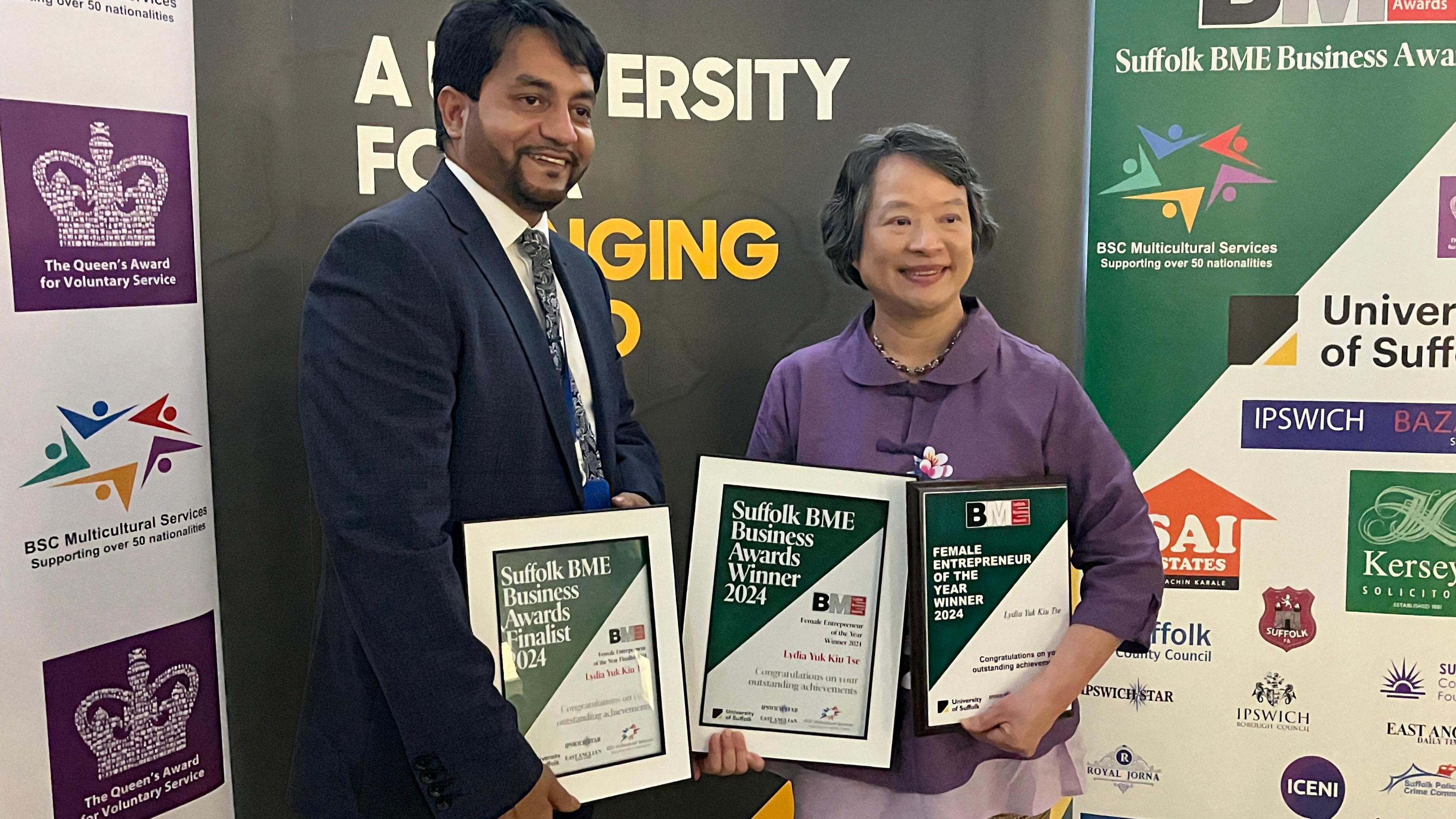 Boshor Ali and Lydia Yuk Kiu Tse stand with award certificates.