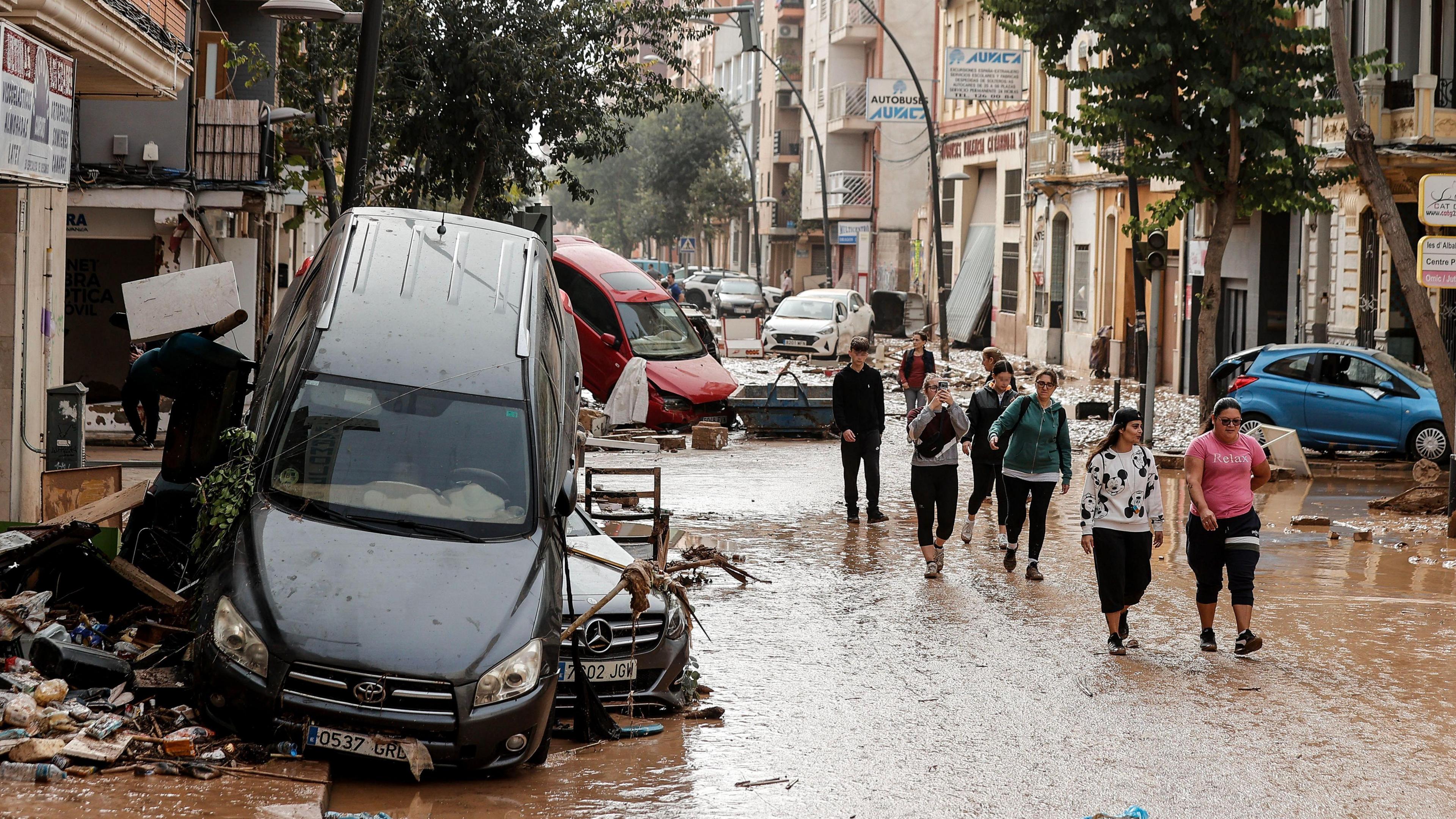 people walking down a flooded street