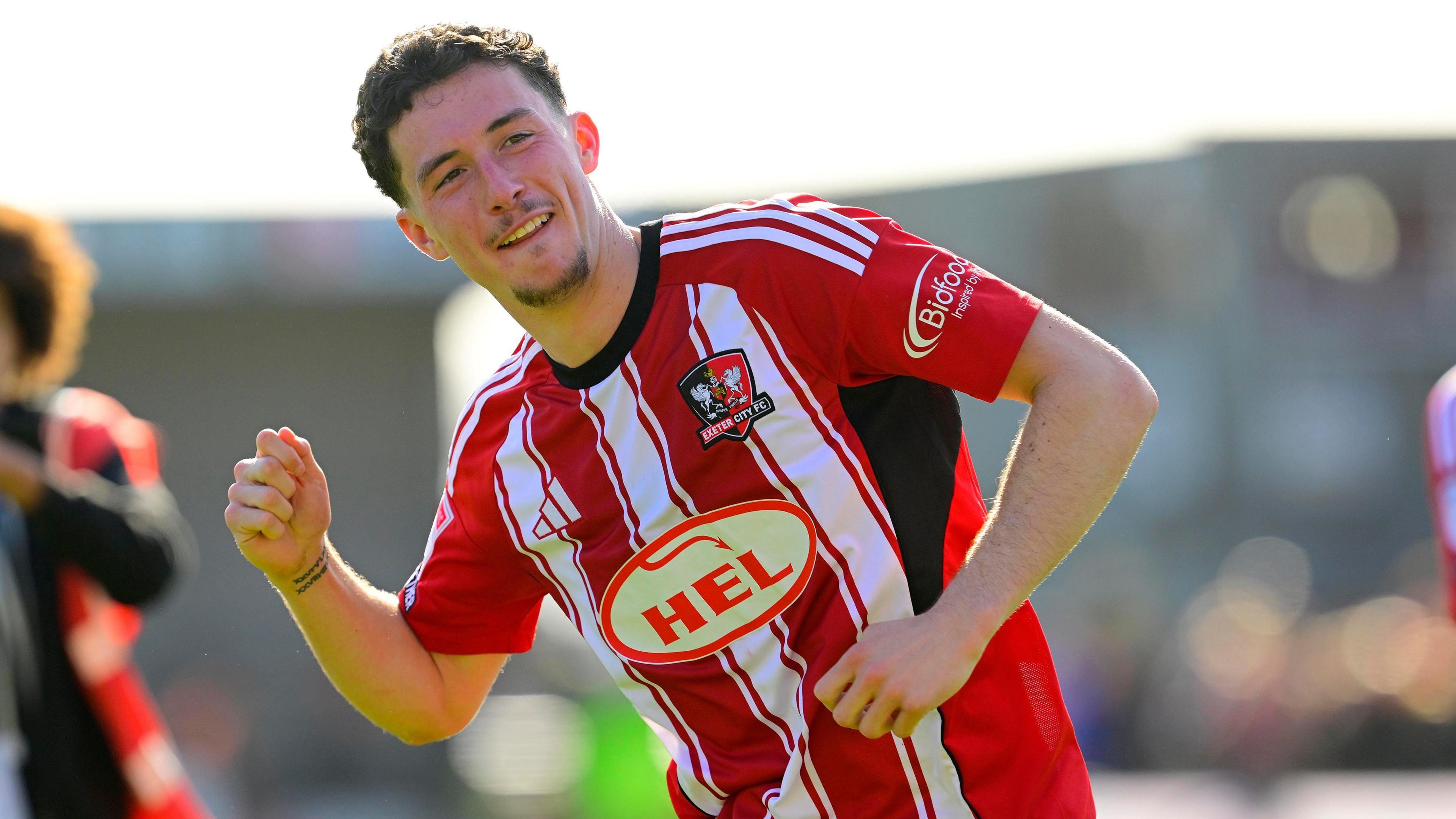 Charlie Cummins celebrates in an Exeter City kit.
