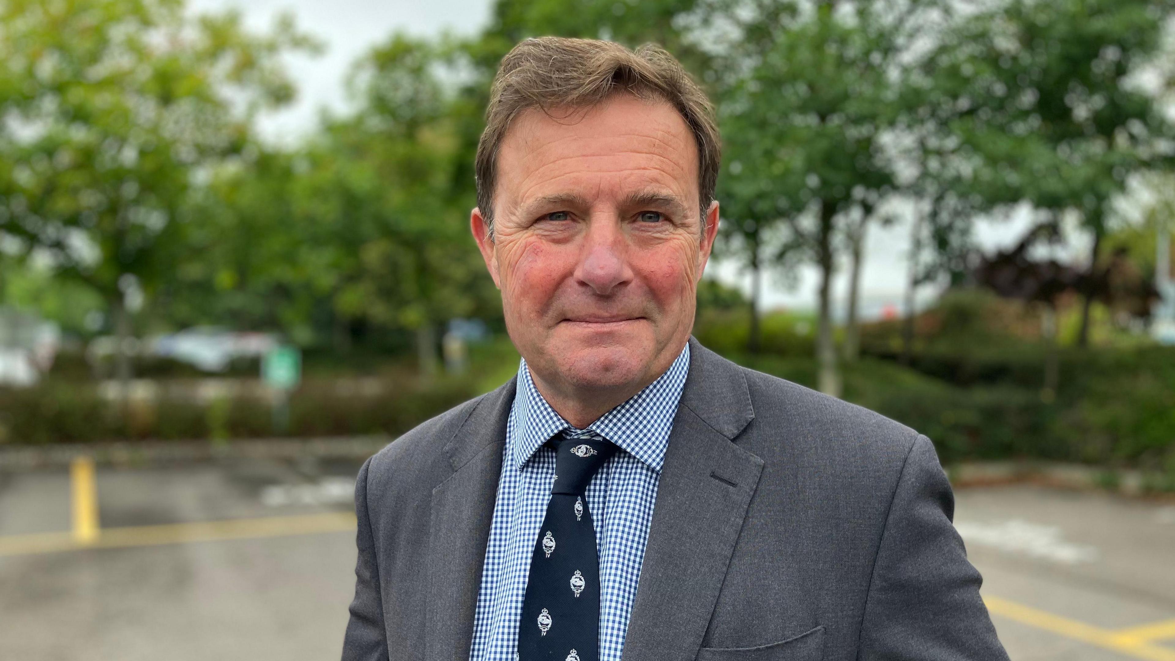 Former Army commander Hamish de Bretton-Gordon looking into camera wearing grey suit jacket, tie and shirt