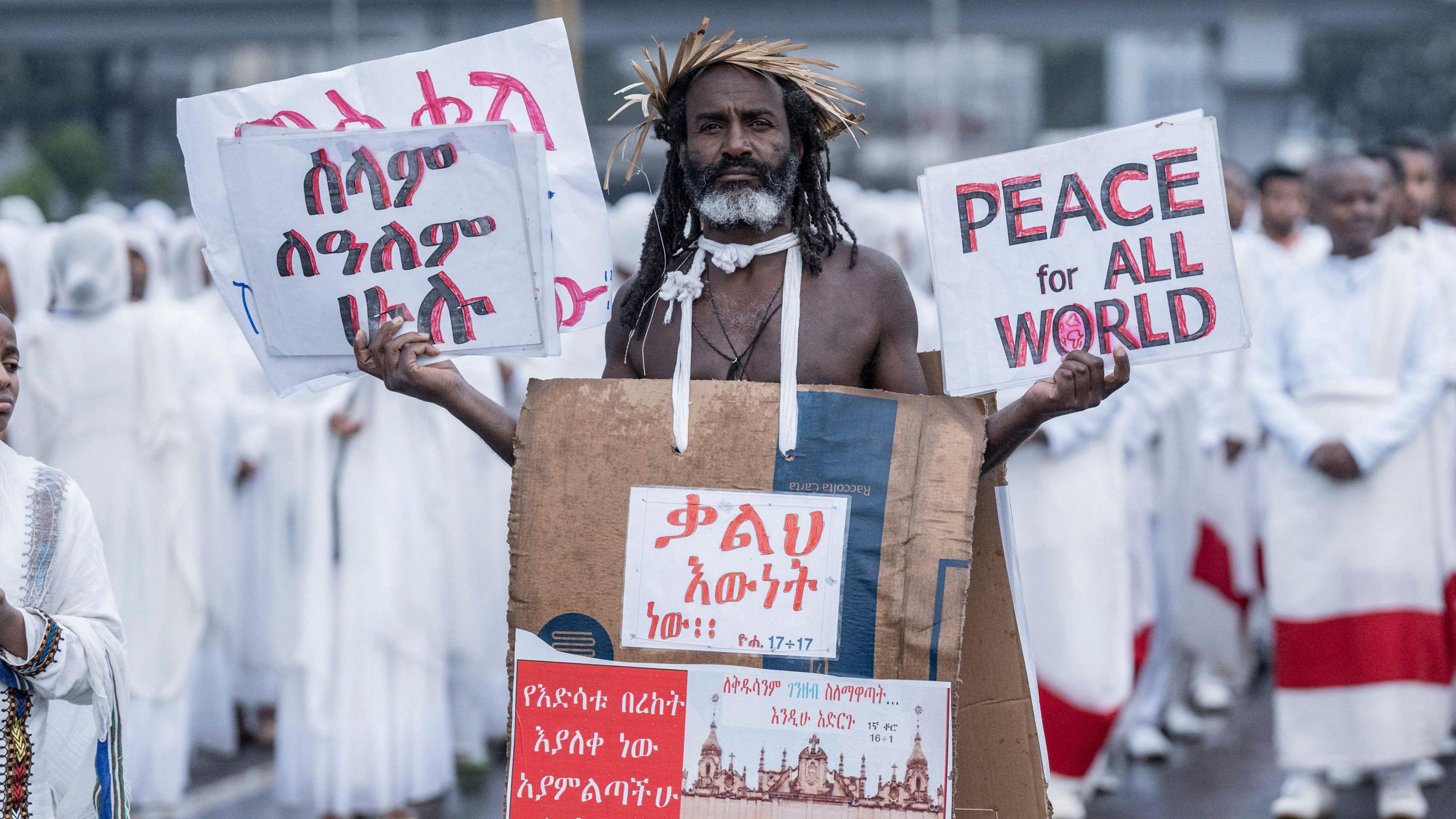 A man holding placards poses for a photograph during the celebrations of the Ethiopian Orthodox holiday of Meskel in Addis Ababa, on September 26, 2024