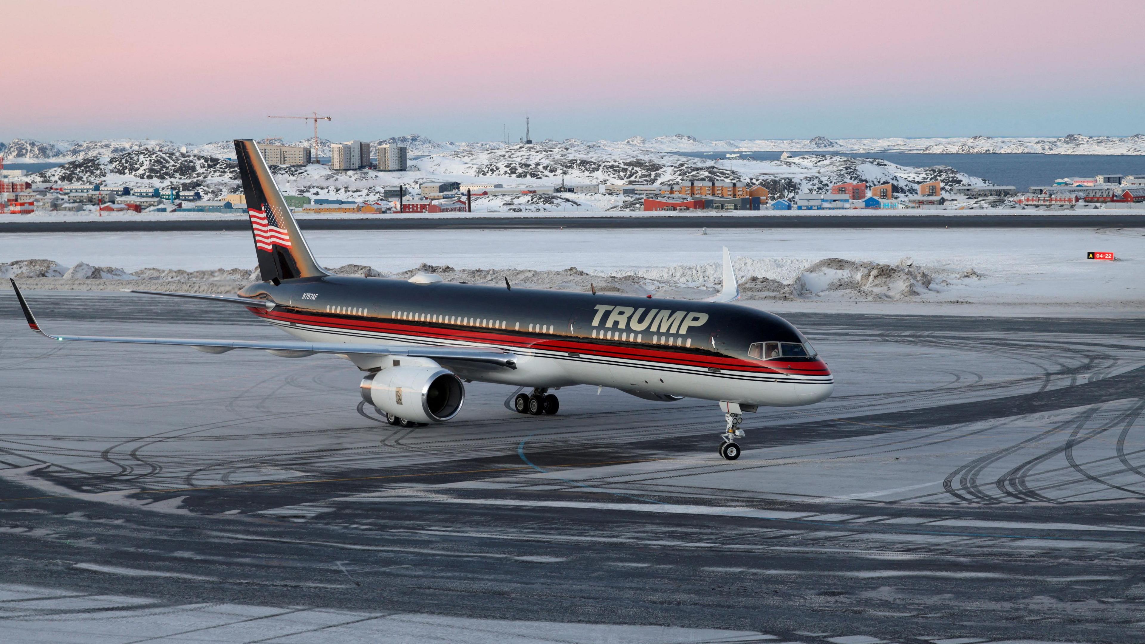 A plane with the words 'Trump' on the side at an airport in Greenland with snow and ice on the tarmac