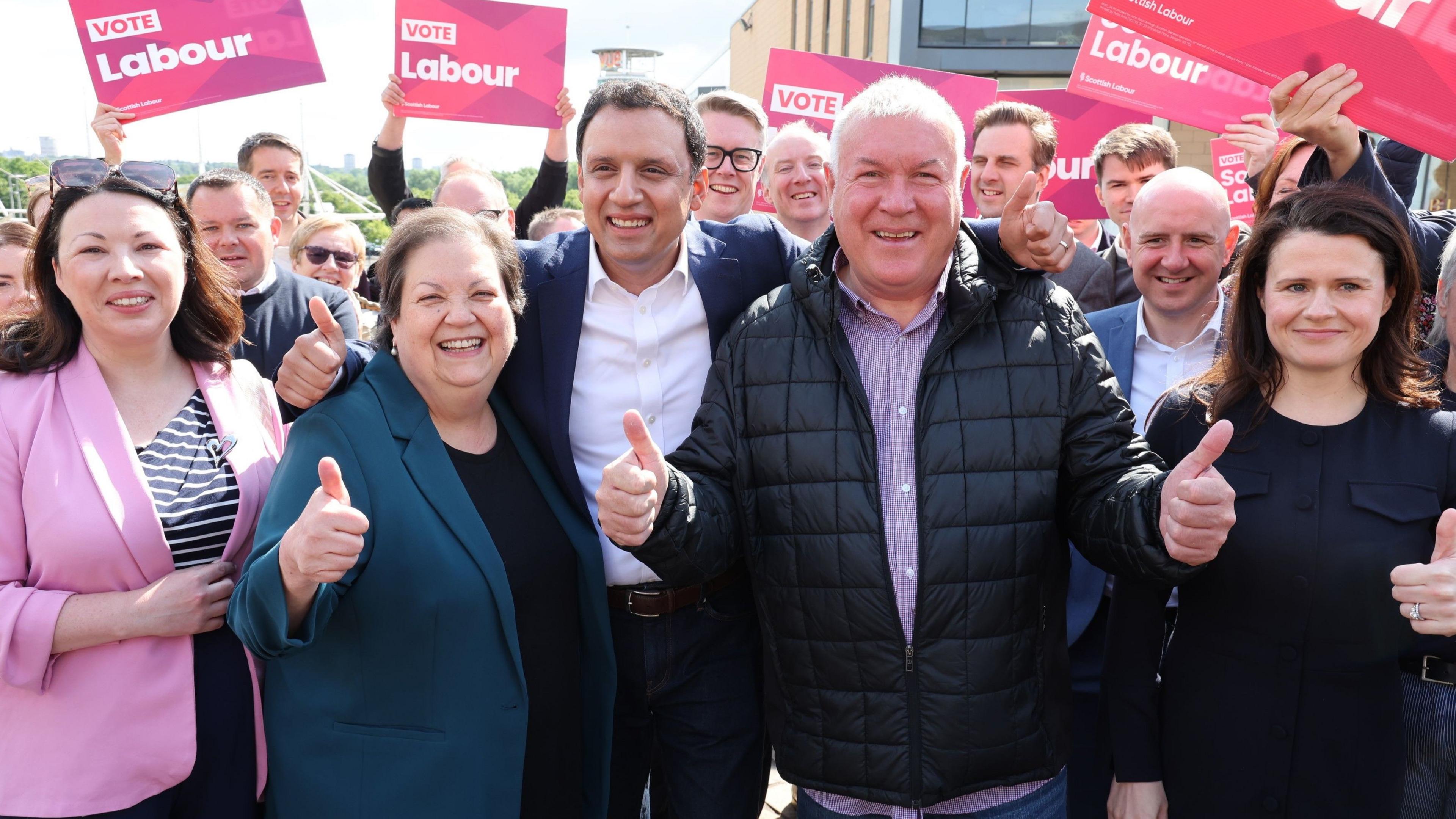 Anas Sarwar and new MP Davy Russell smiling and holding up their fists as they celebrate their victory