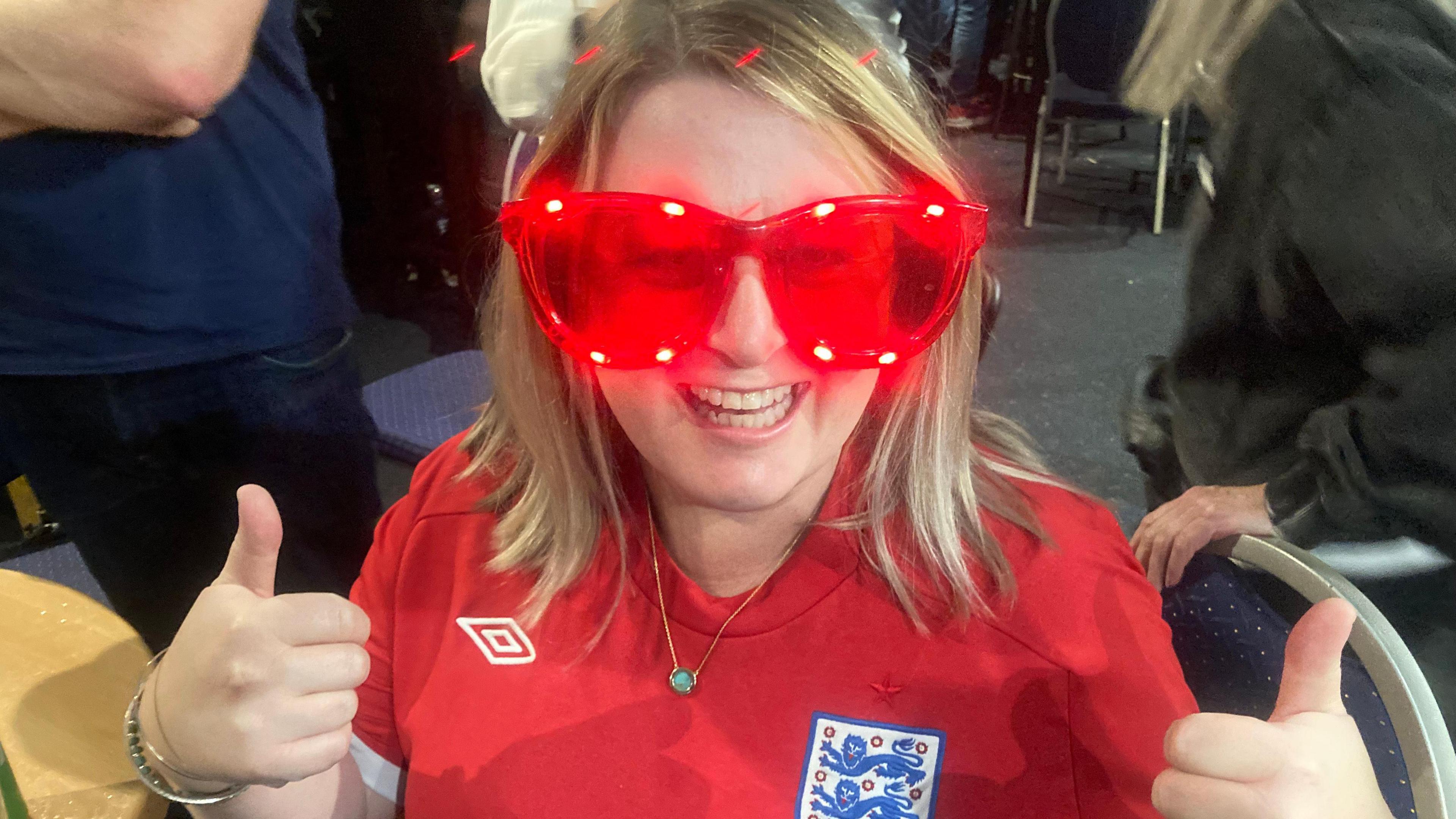 Woman in coloured glasses enjoying the football