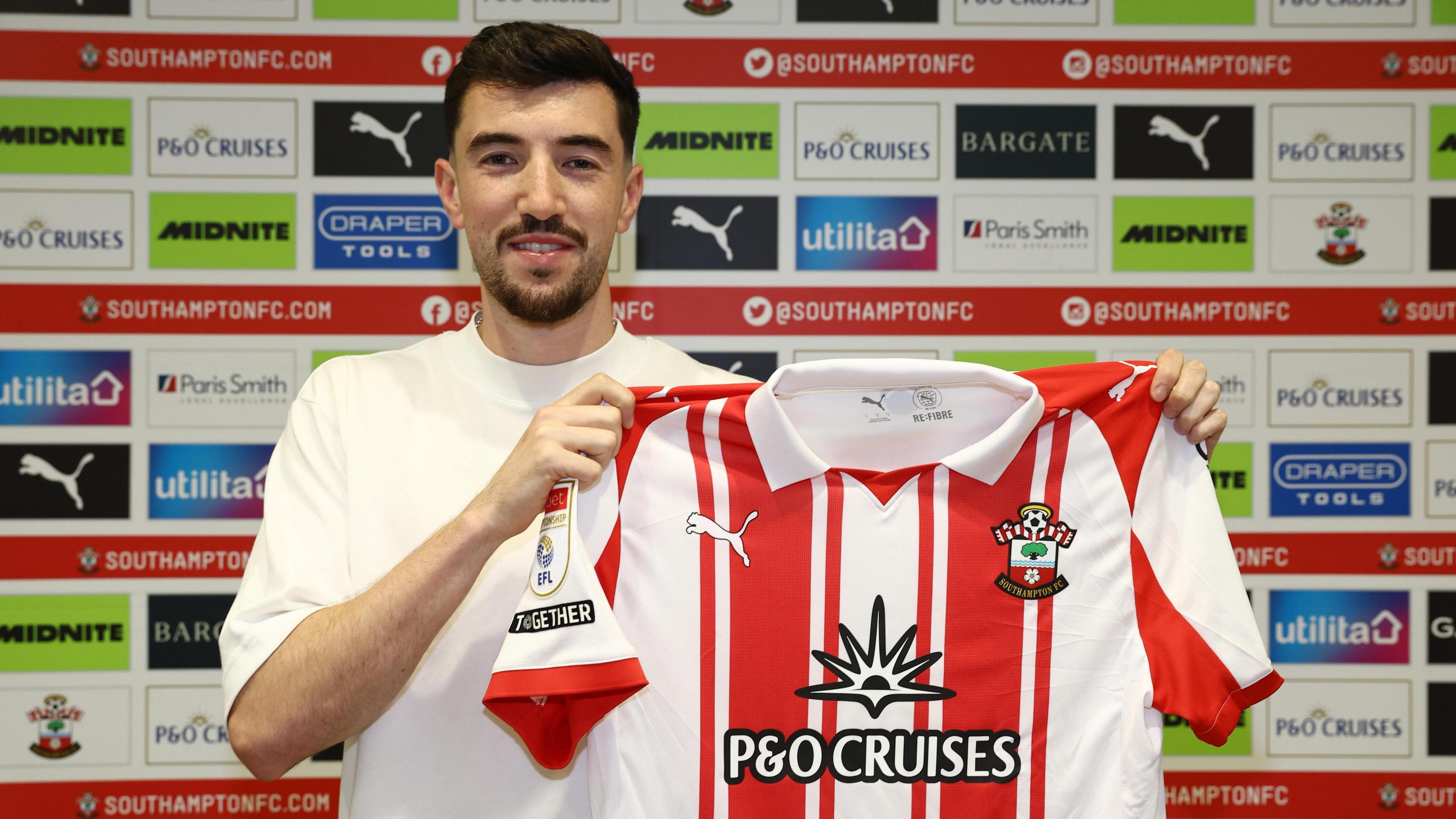 New signing Finn Azaz holding a Southampton shirt after signing for the club 