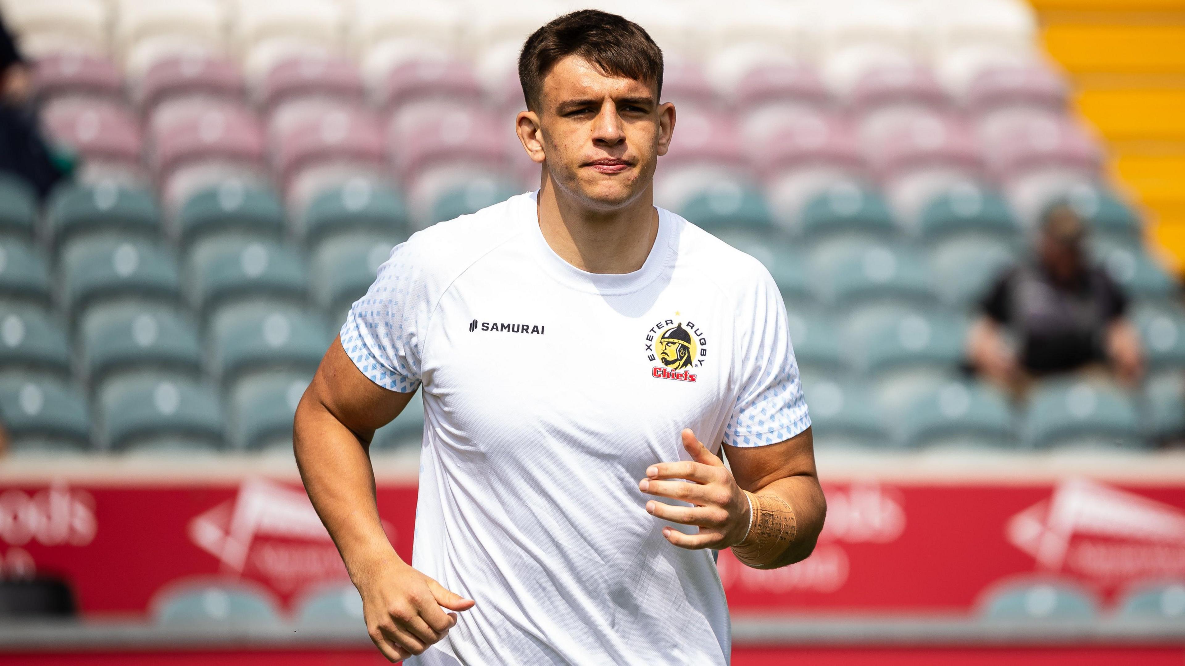 Dafydd Jenkins running on the pitch during a pre-game warm-up for Exeter