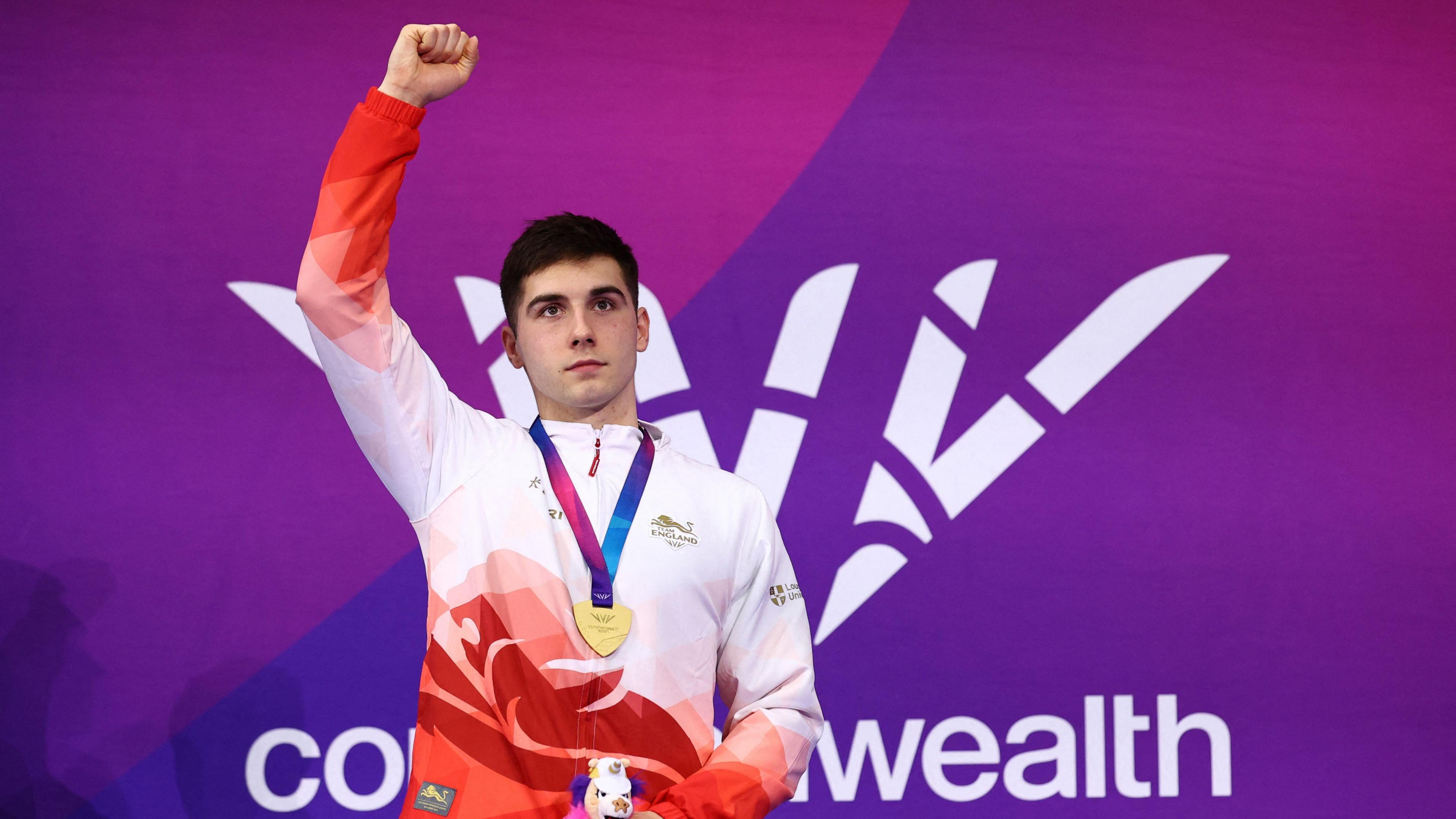 Will Ellard puts his fist up in the air as he collects his gold medal for the men's 200m freestyle S14 in Glasgow