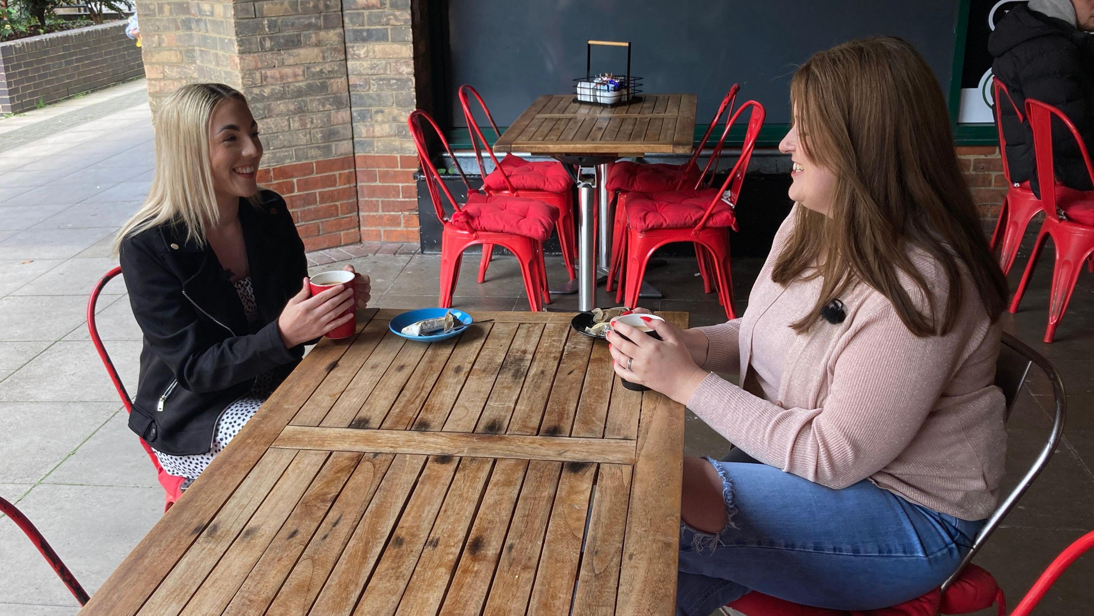 Gemma Cutler sitting in a cafe with Jen Moore