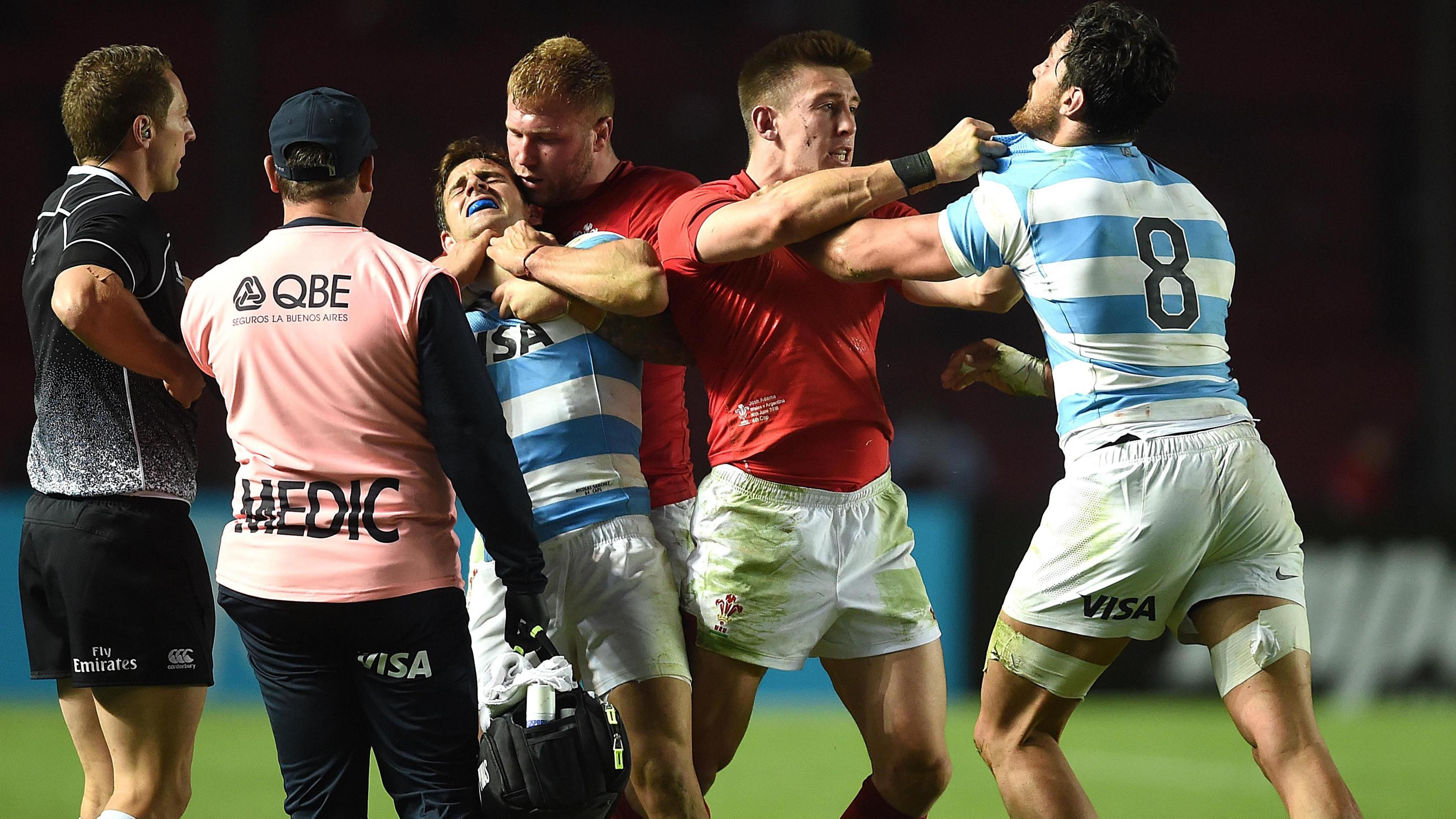 Match officials watch as Ross Moriarty and Josh Adams of Wales grapple with Nicolas Sanchez and Javier Ortega Desio of Argentina 