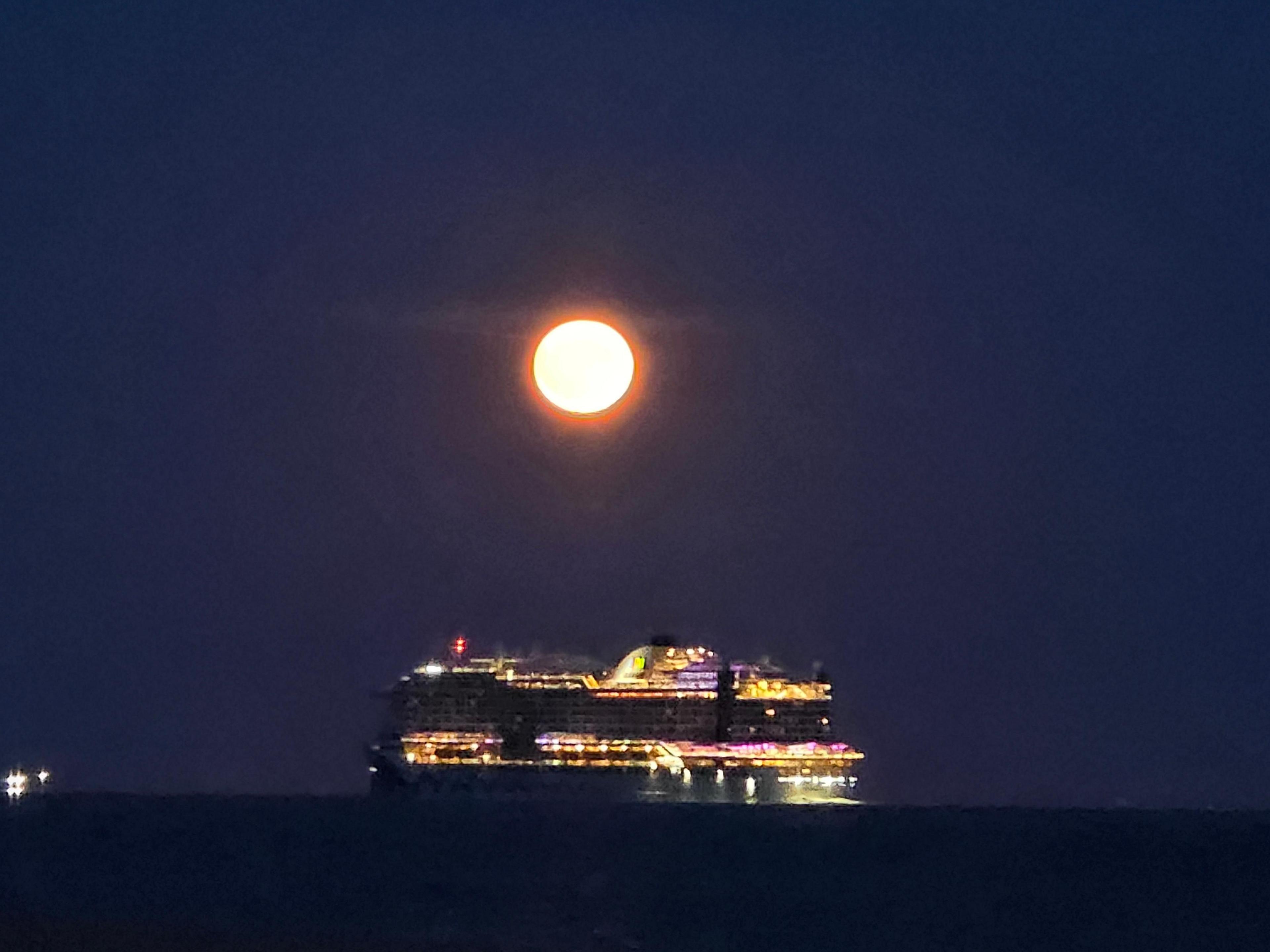 Gosport with cruise ship passing glowing Strawberry Moon