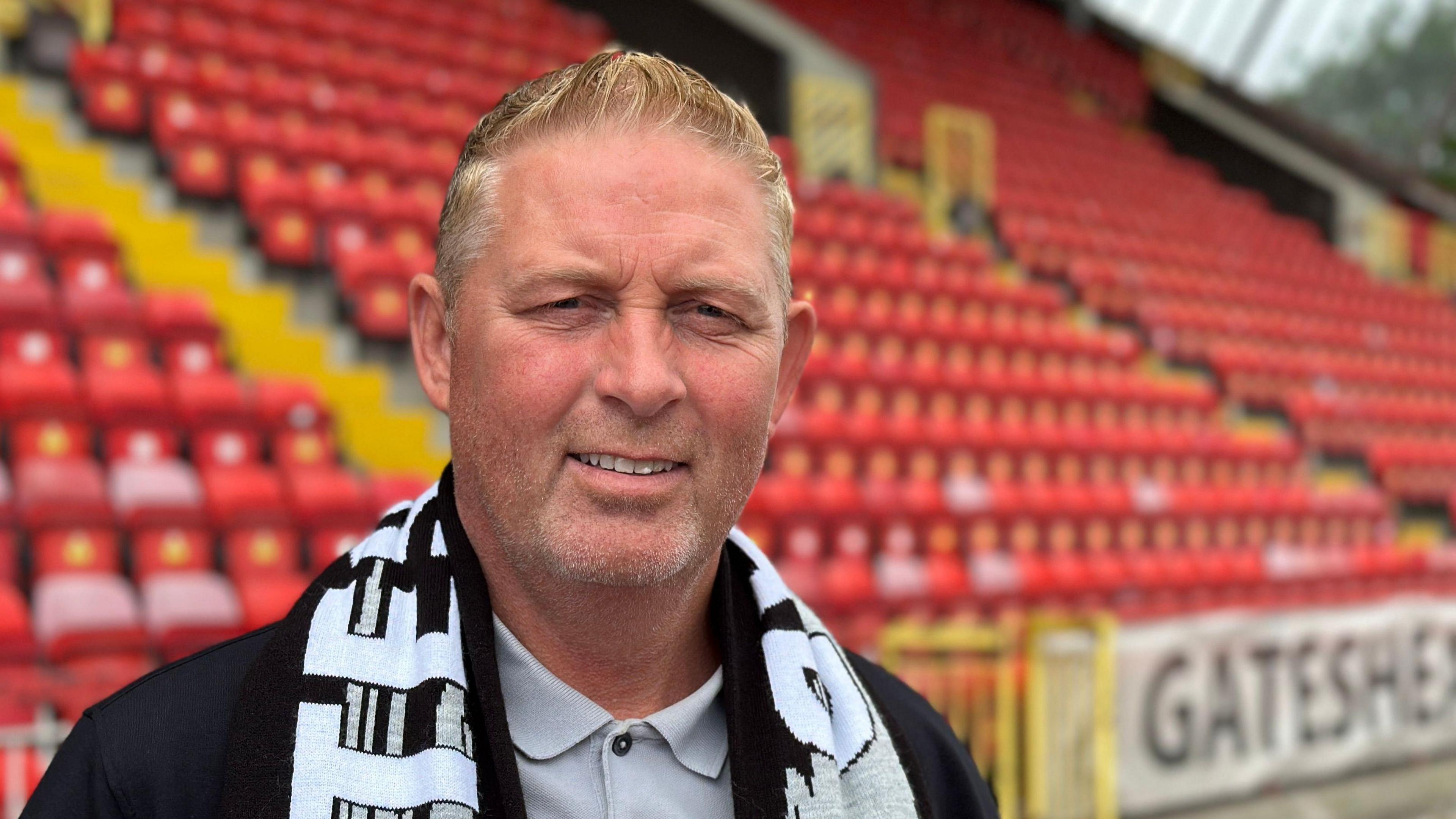Alun Armstrong stands with a Gateshead scarf on after his appointment in summer 2025