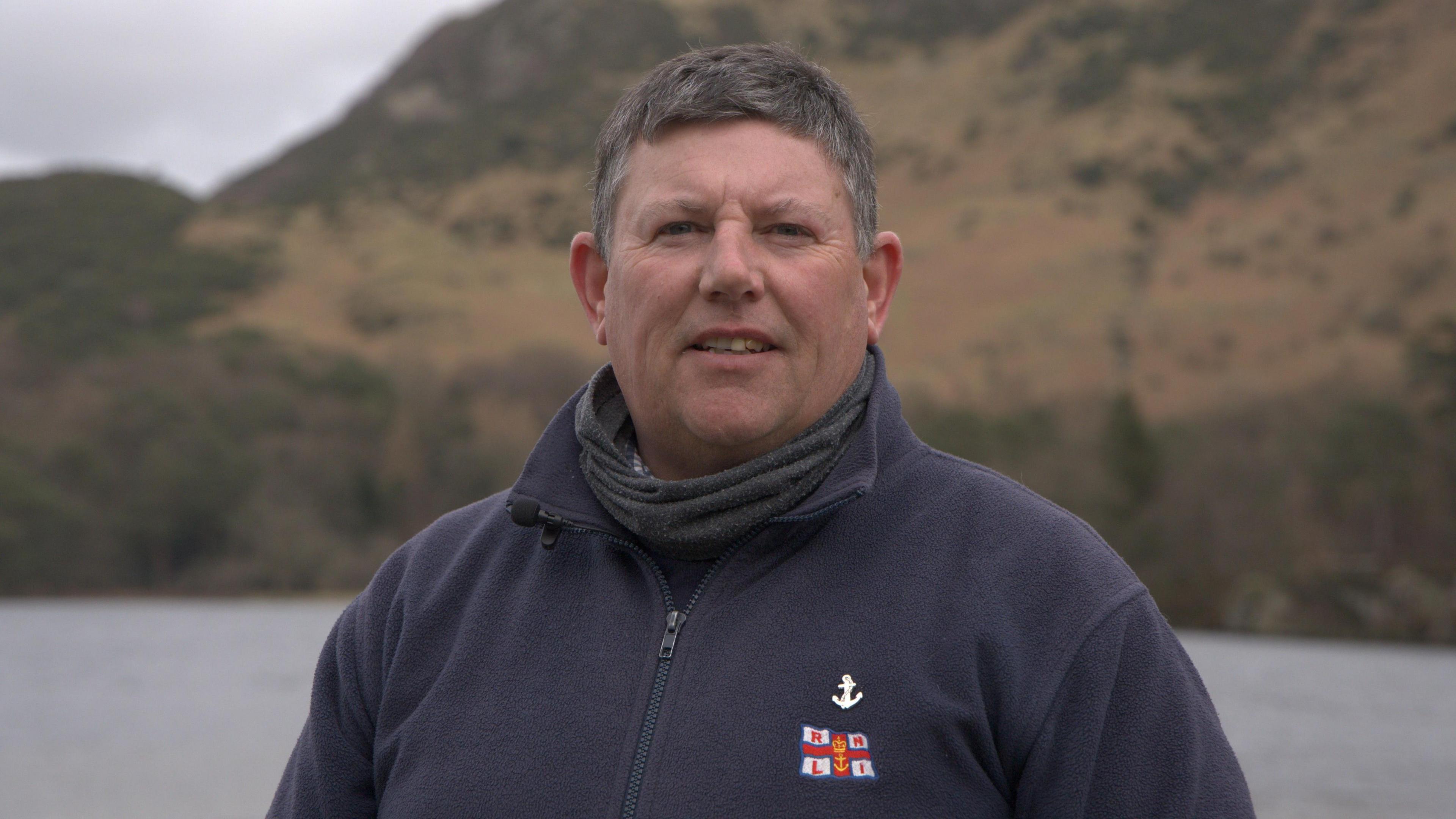 Andrew Price standing in front of Coniston Water