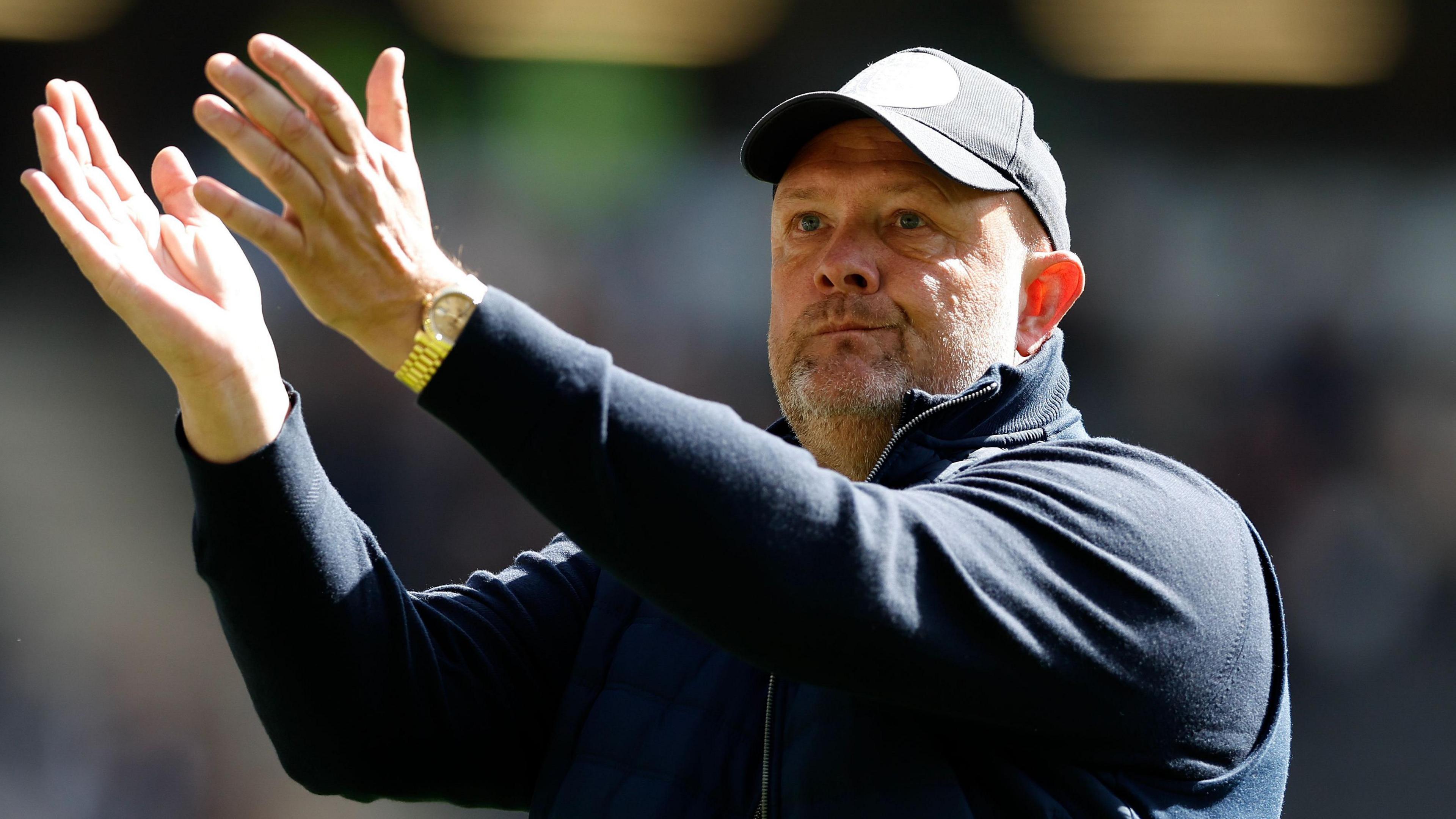 Bromley boss Andy Woodman applauds the fans after their loss at MK Dons.