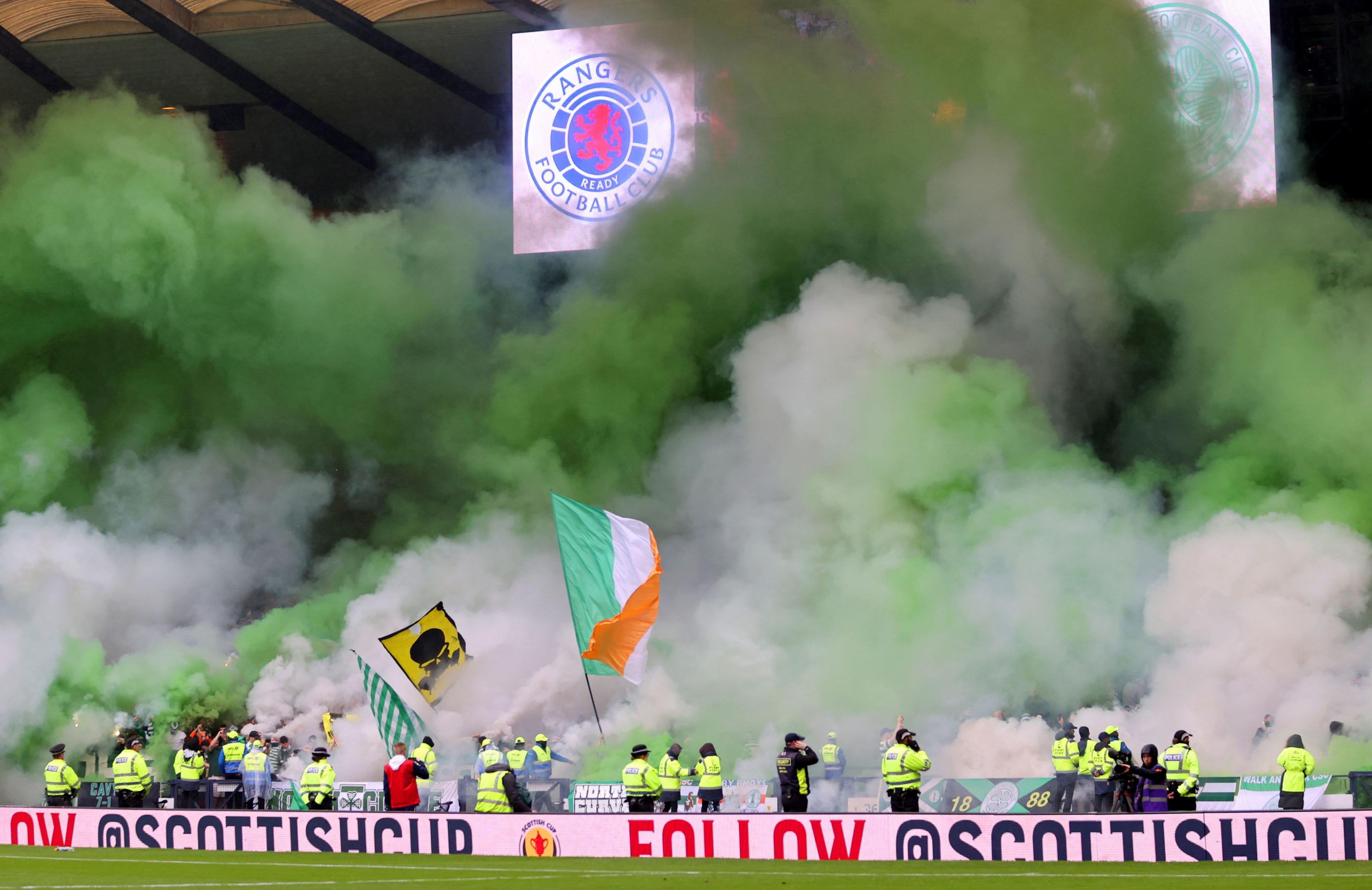 Green and white smoke flares are set off during the Scottish Cup semi-final match at Hampden Park, Glasgow in 2023