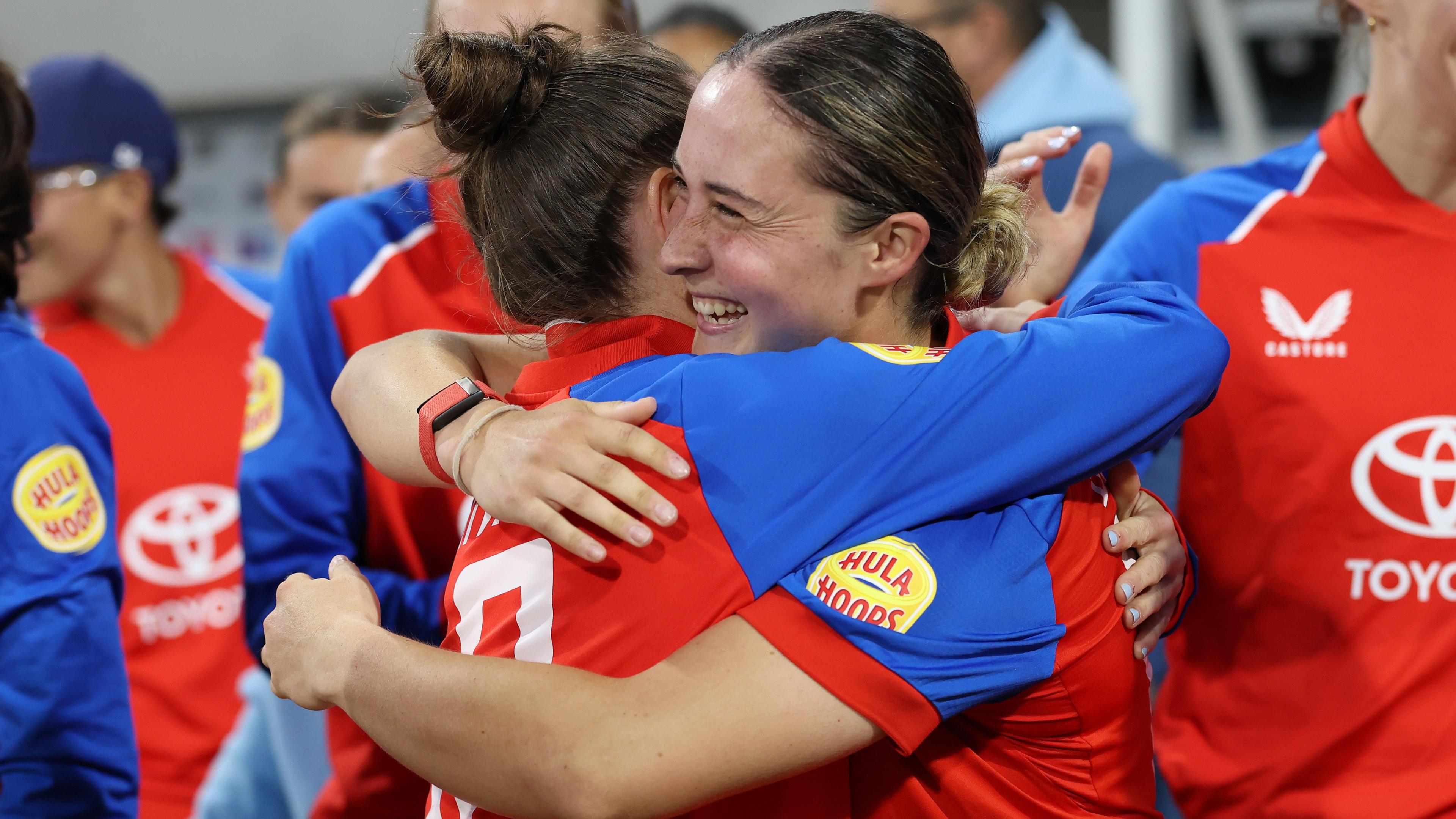 Alice Capsey is hugged by a team-mate