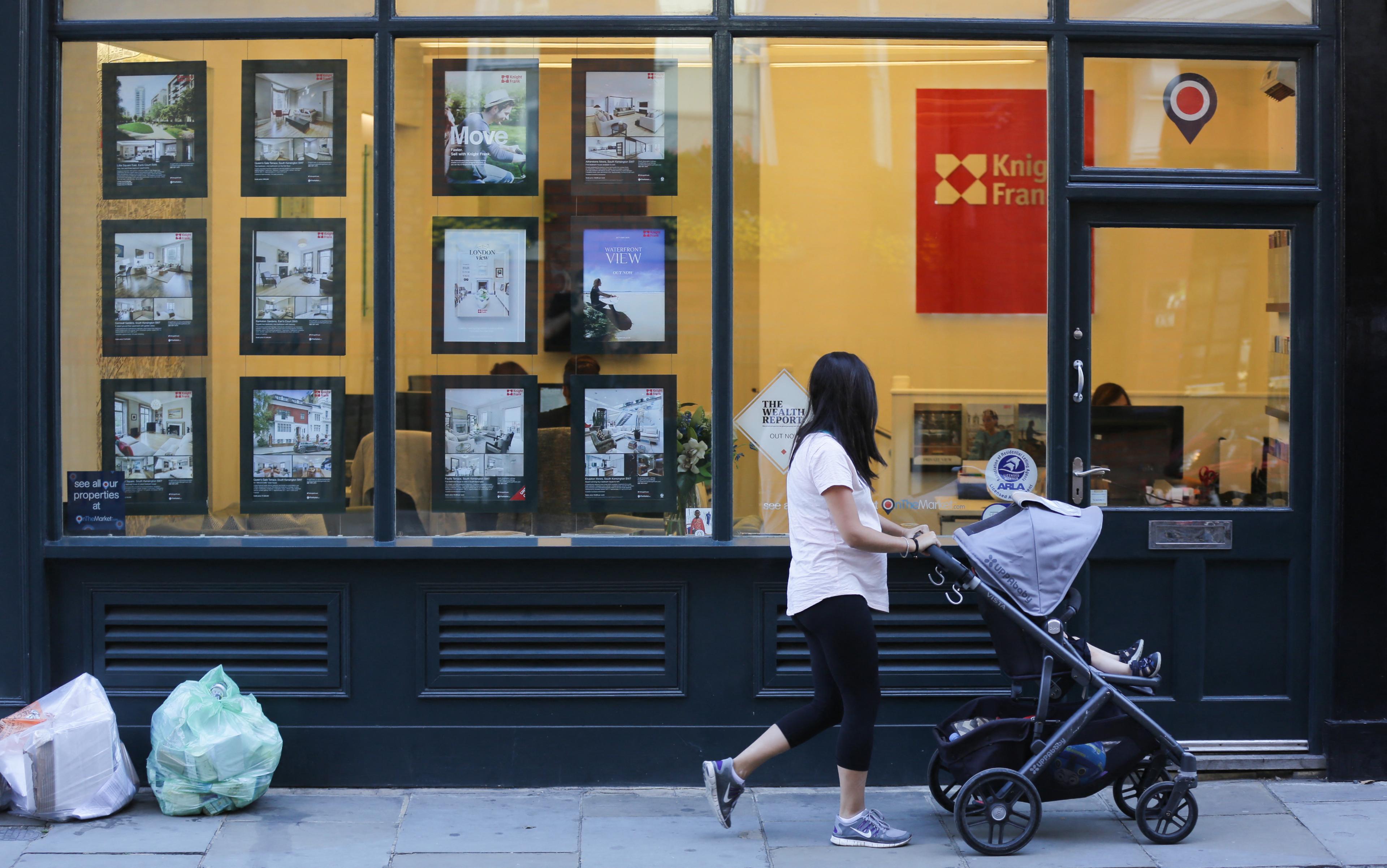 Woman walks past estate agent