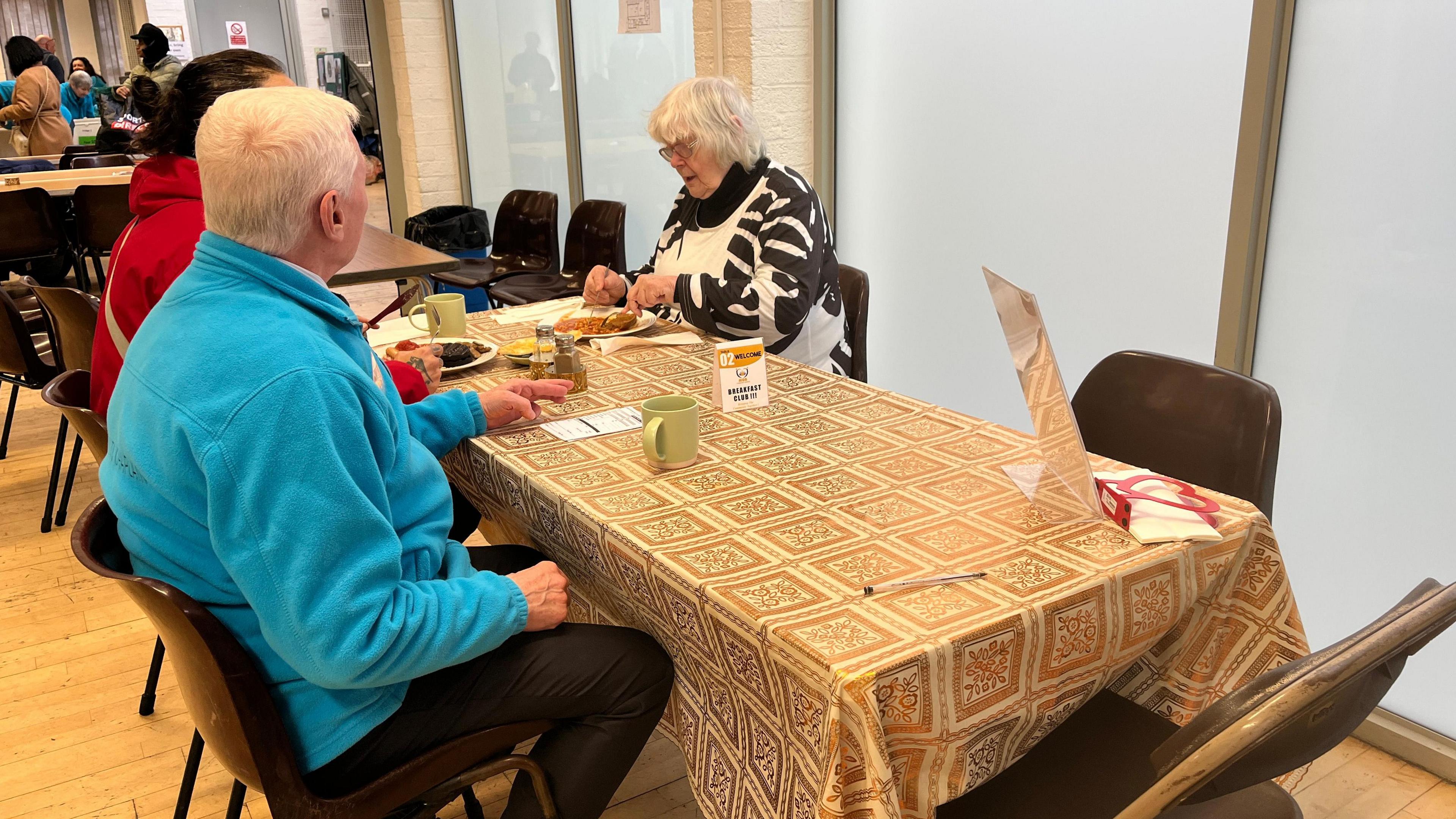 Volunteers chat around a table at the Making Good Better breakfast club in Milton Keynes