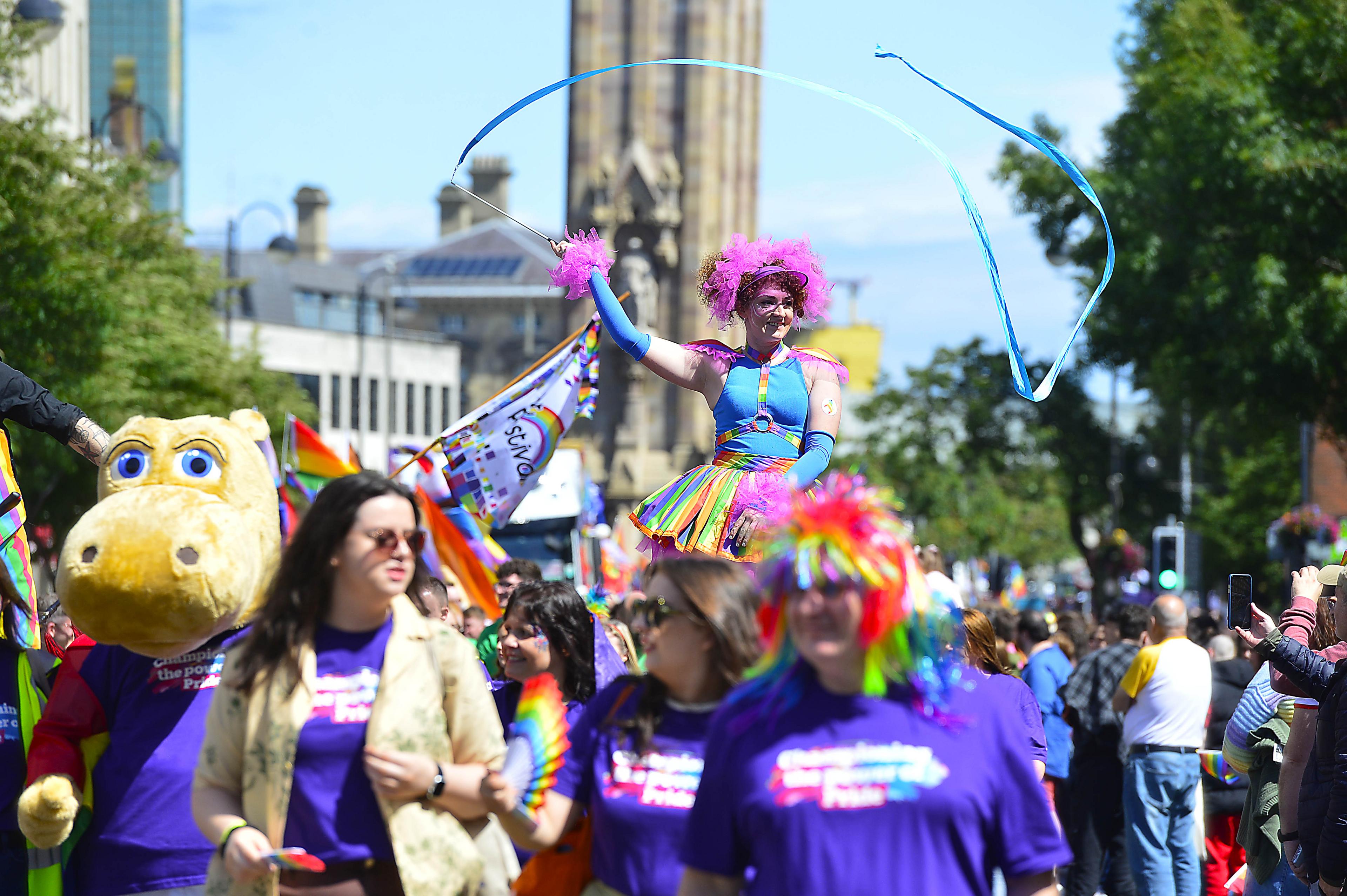 A person in a colourful costume waves a flag