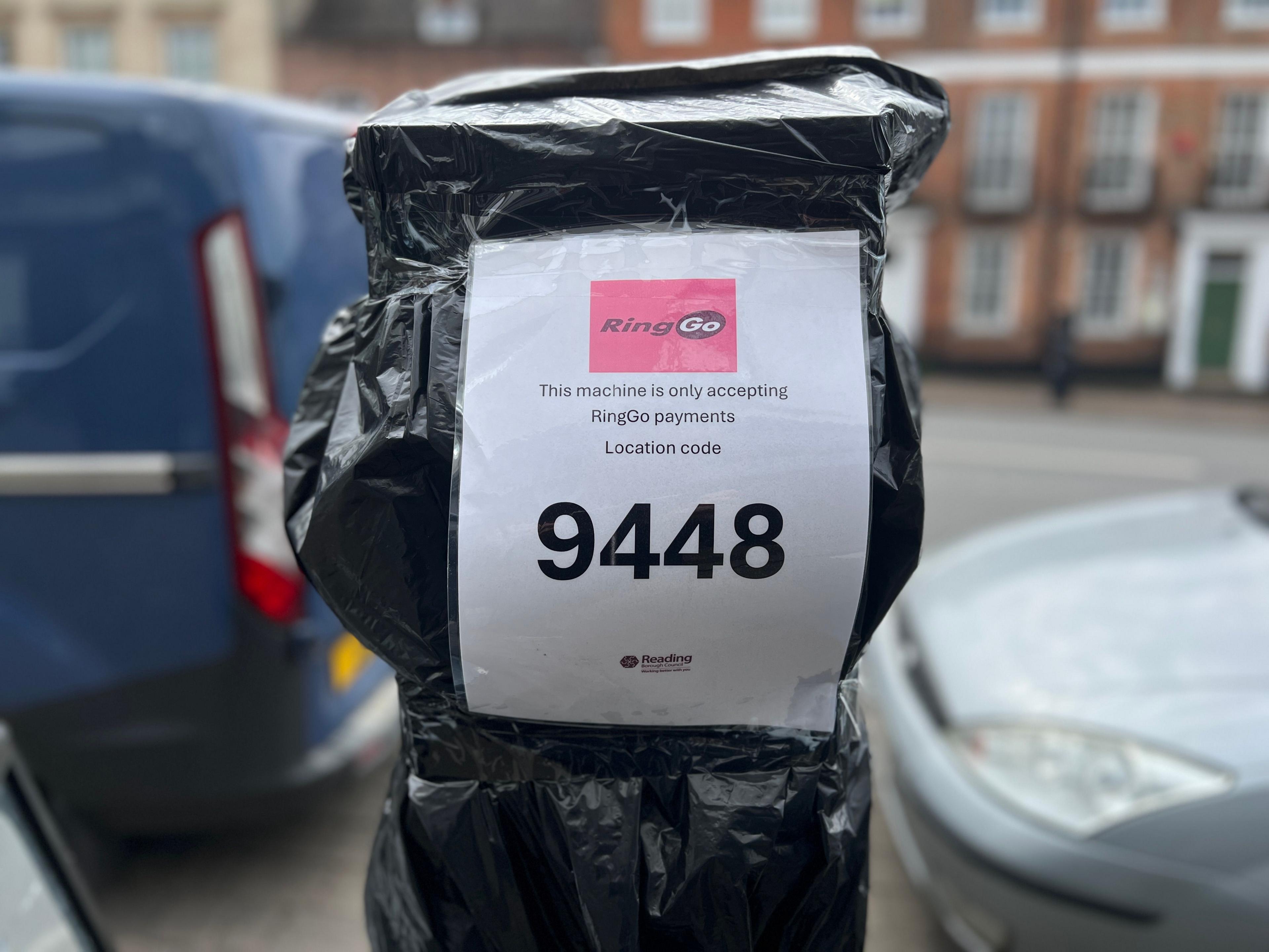 A car parking ticket machine covered with black plastic on London St, Reading, stating people must use RingGo to pay. 