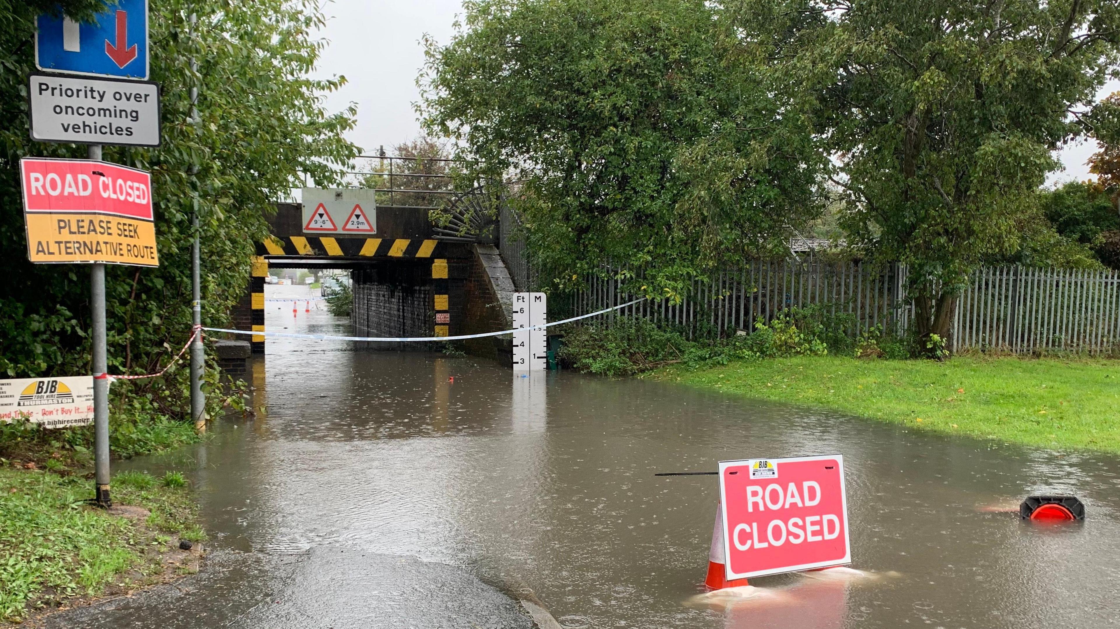 A flooded Church Hill Road in Thurmaston, Leicestershire, beneath a railway bridge