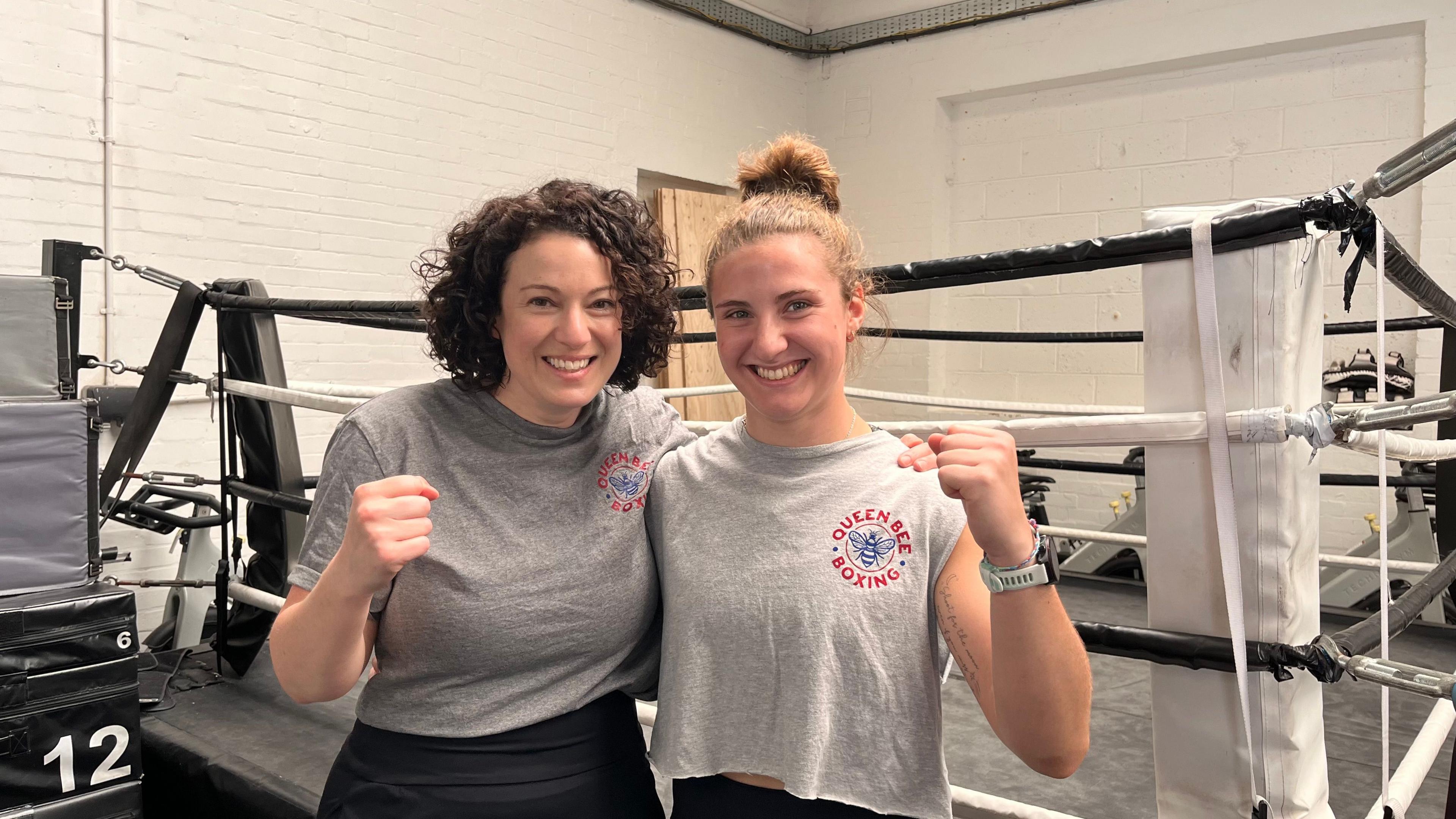 Nadia Finer and Izzy Kelly holding up their fists and smiling