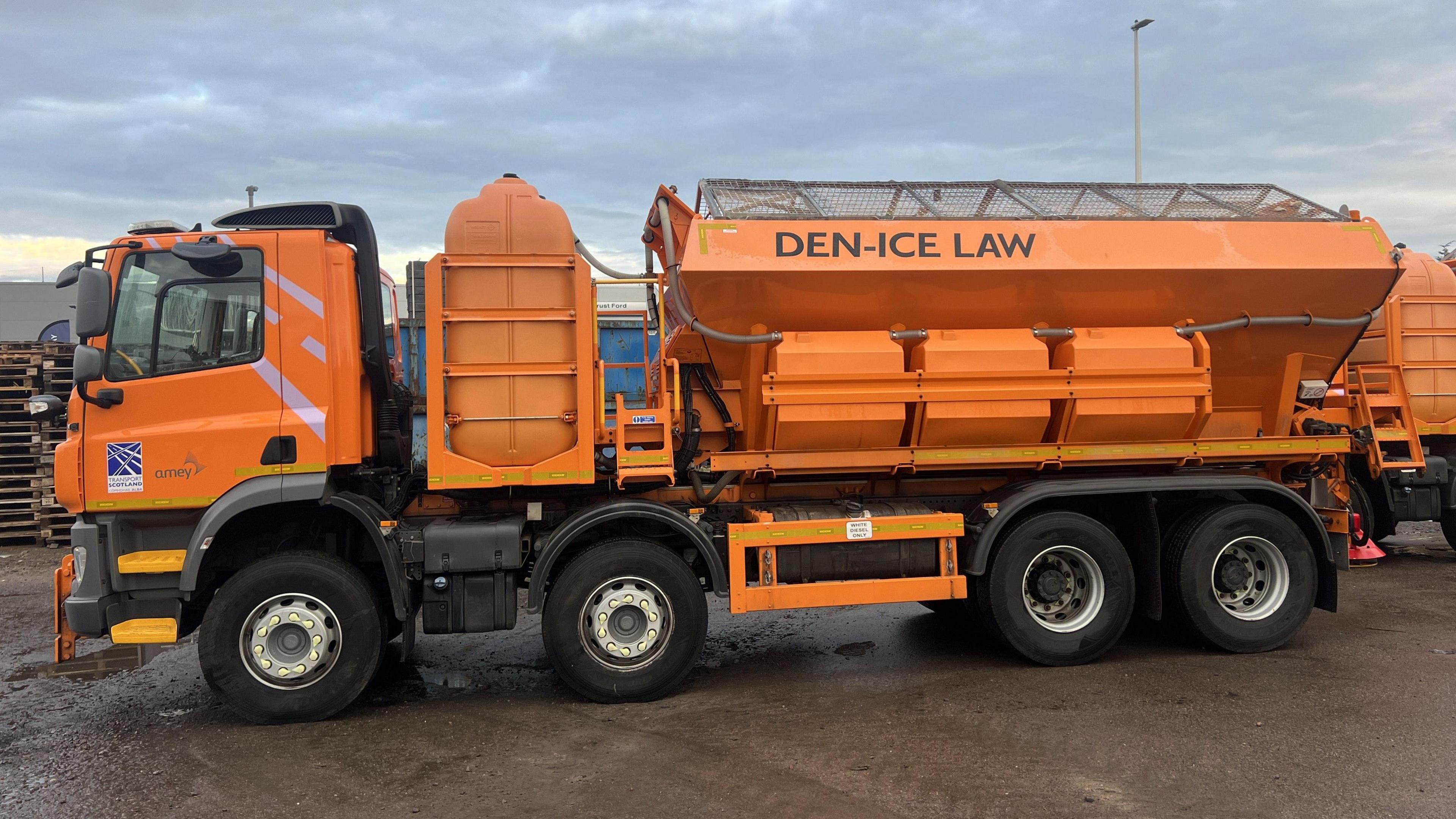 Side view of the bright orange Amey gritter named Den-Ice Law in honour of the football legend