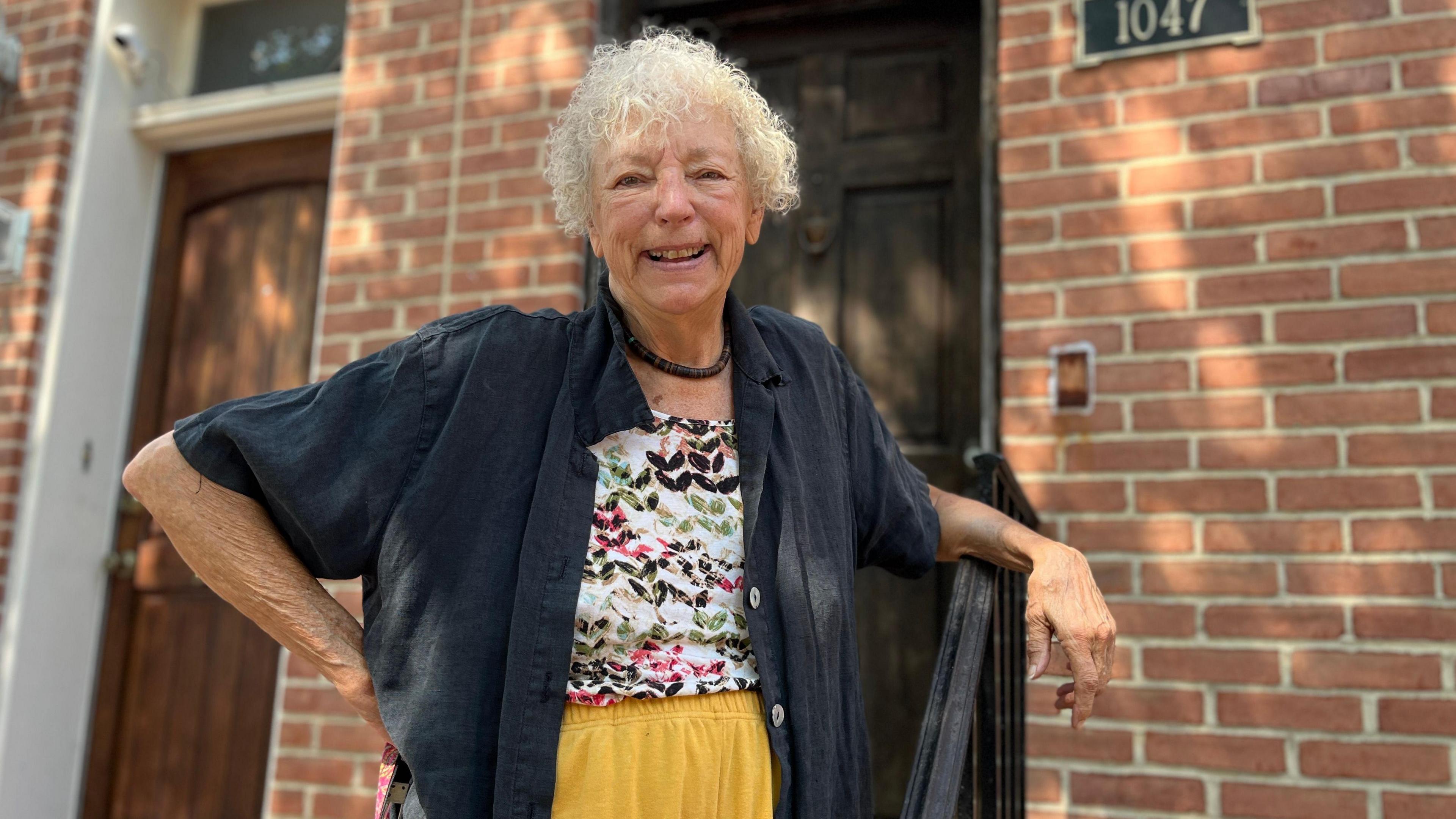 Judy Aleksalza smiling outside of her home.