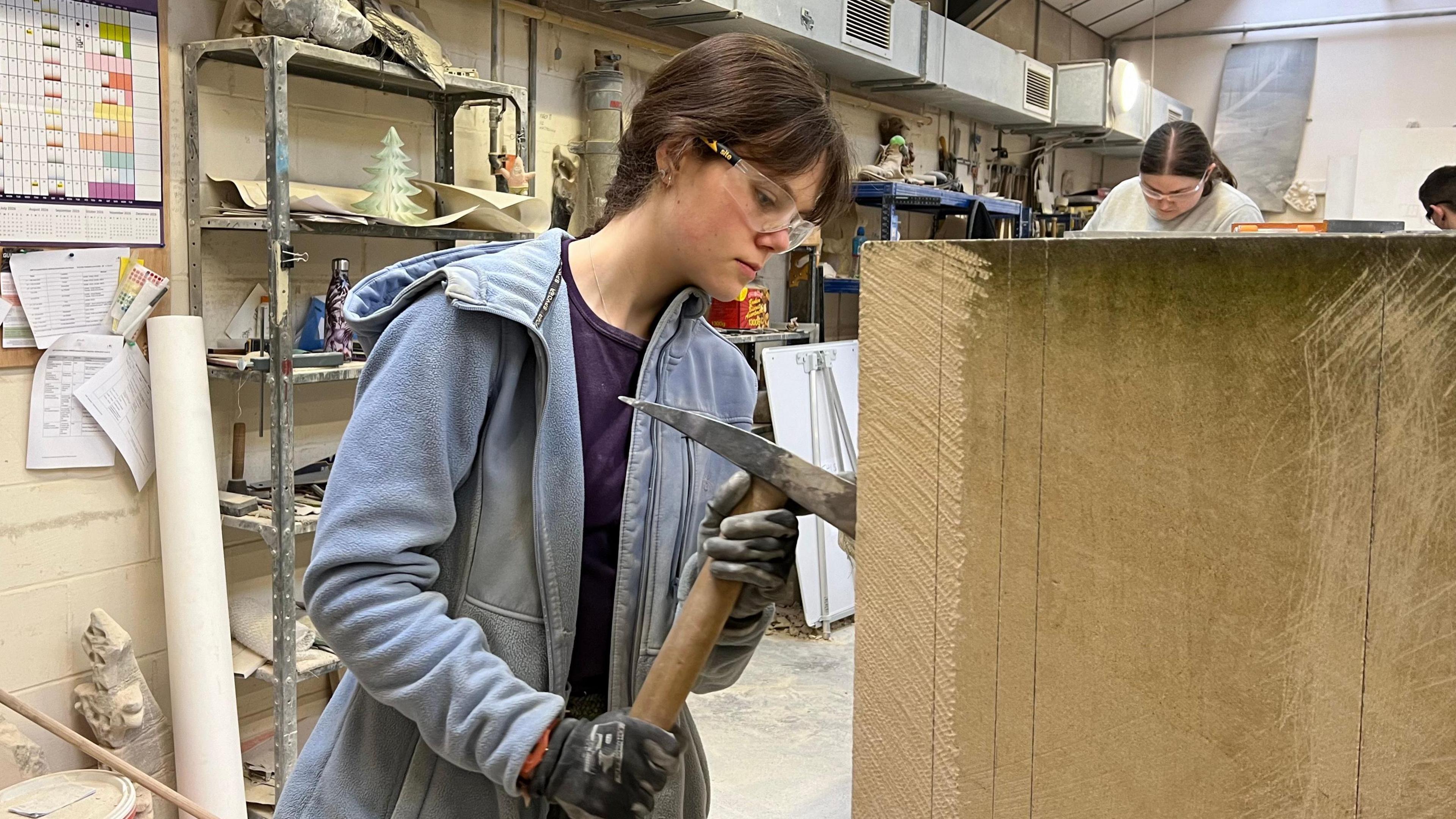 Lucy Newlyn demonstrating her stonemasonry skills in Gloucester Cathedral's workshop