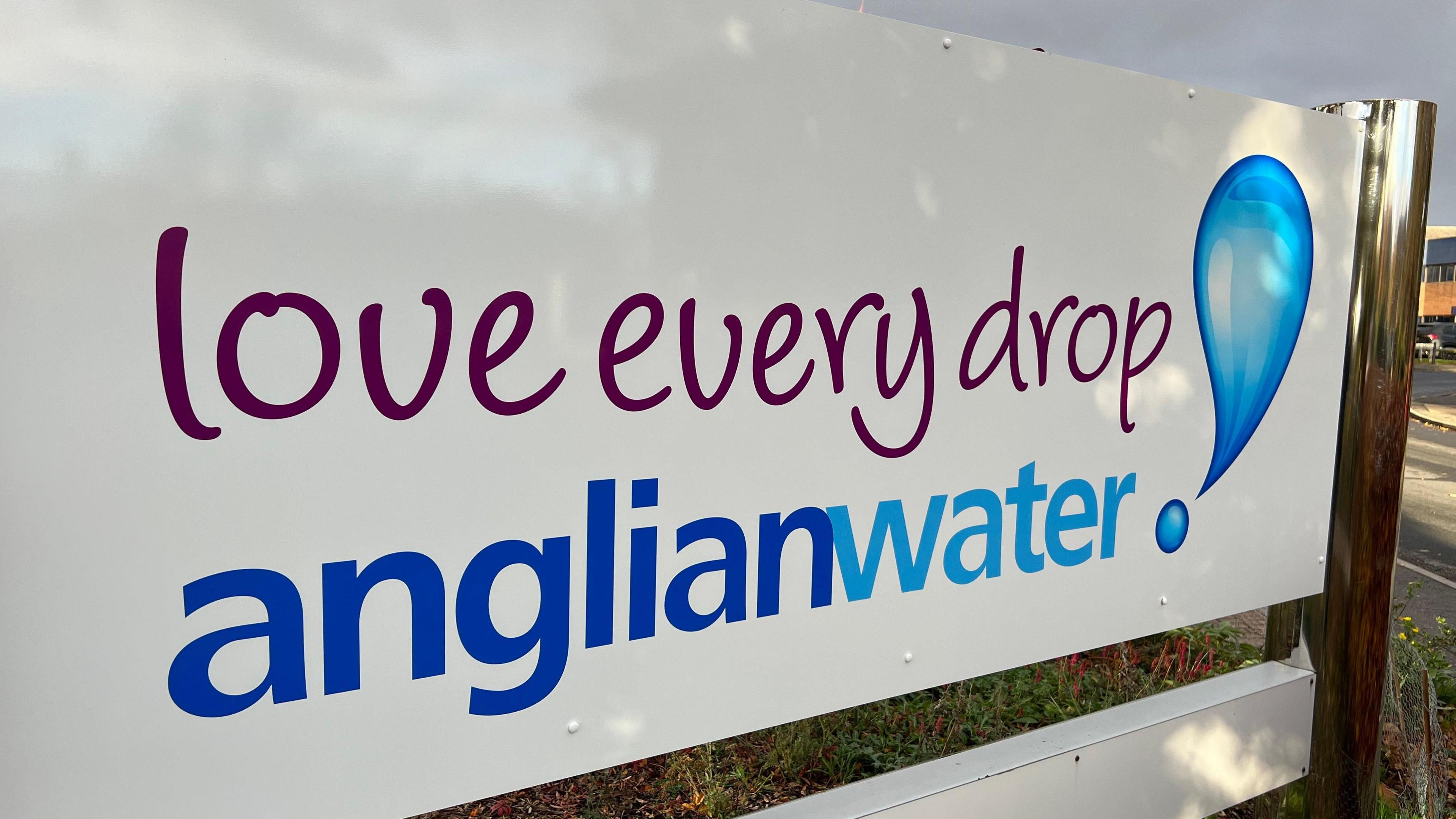 A white sign with the words: "Love every drop Anglian Water".
