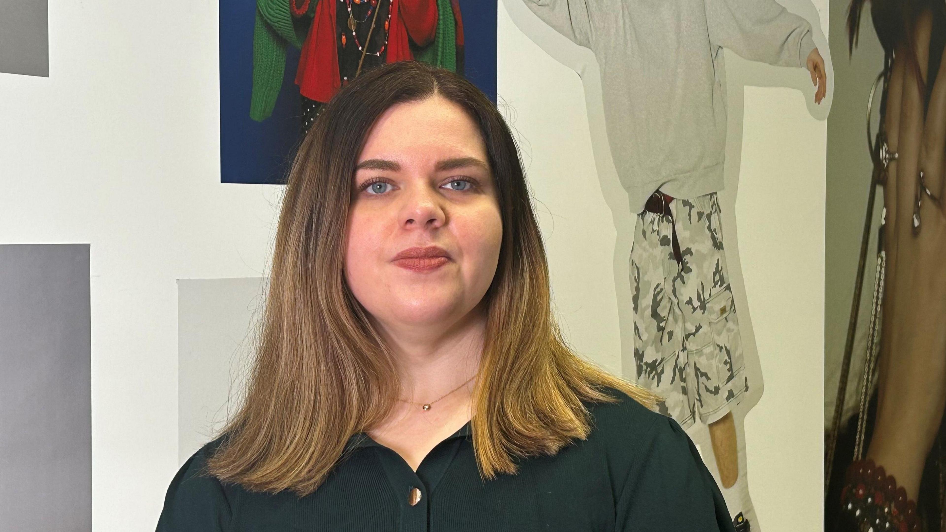 Mae Dr Lauren Thomas yn edrych yn syth ymlaen. Mae ganddi wallt brown at ei hysgwyddau. Mae'n gwisgo crys du ac mae posteri tu nol iddi ar y wal. Mae'r posteri yn dangos delweddau yn ymwneud â ffasiwn. 