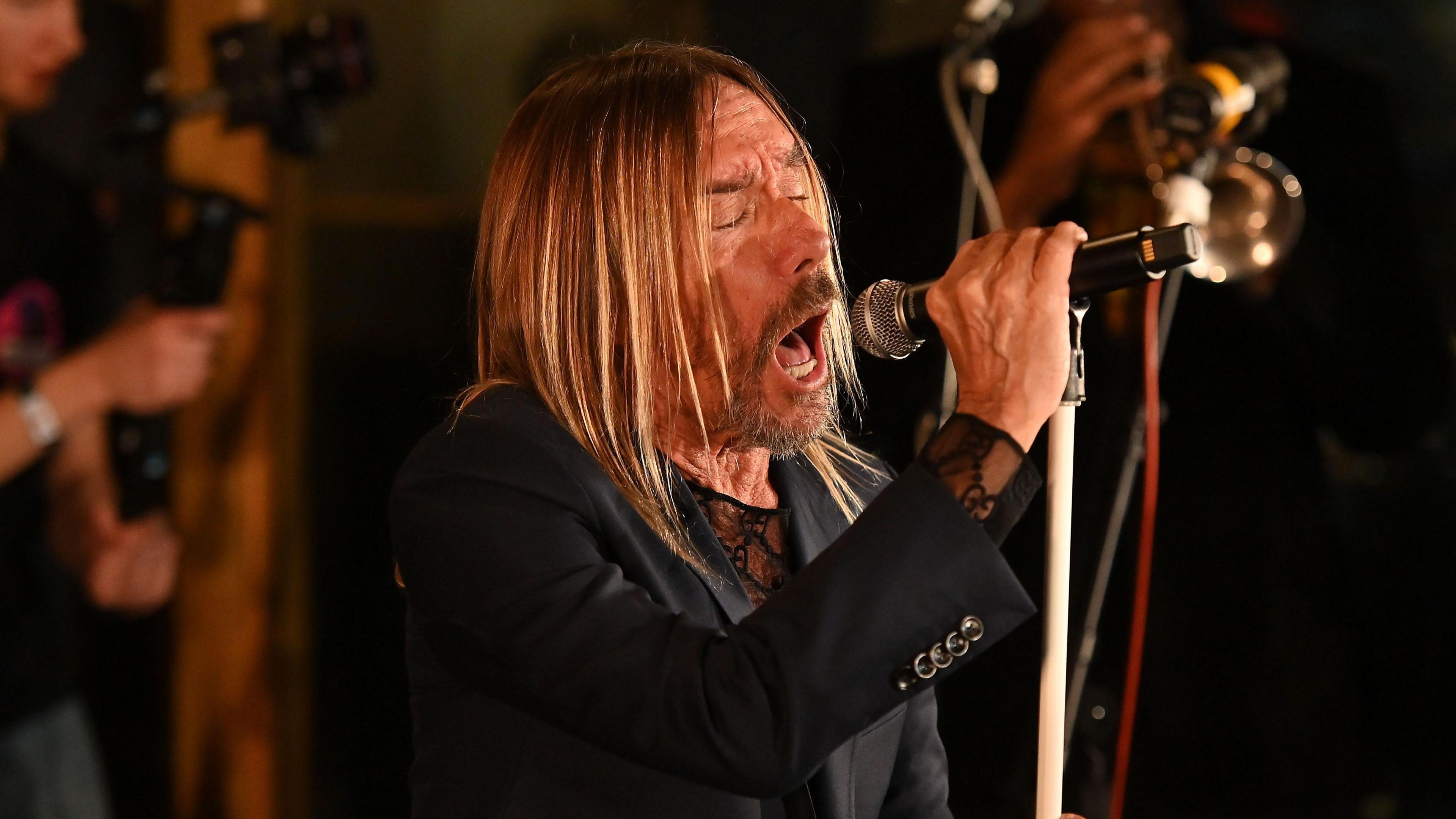 Iggy Pop pictured holding a microphone while singing at BBC's Maida Vale studios.