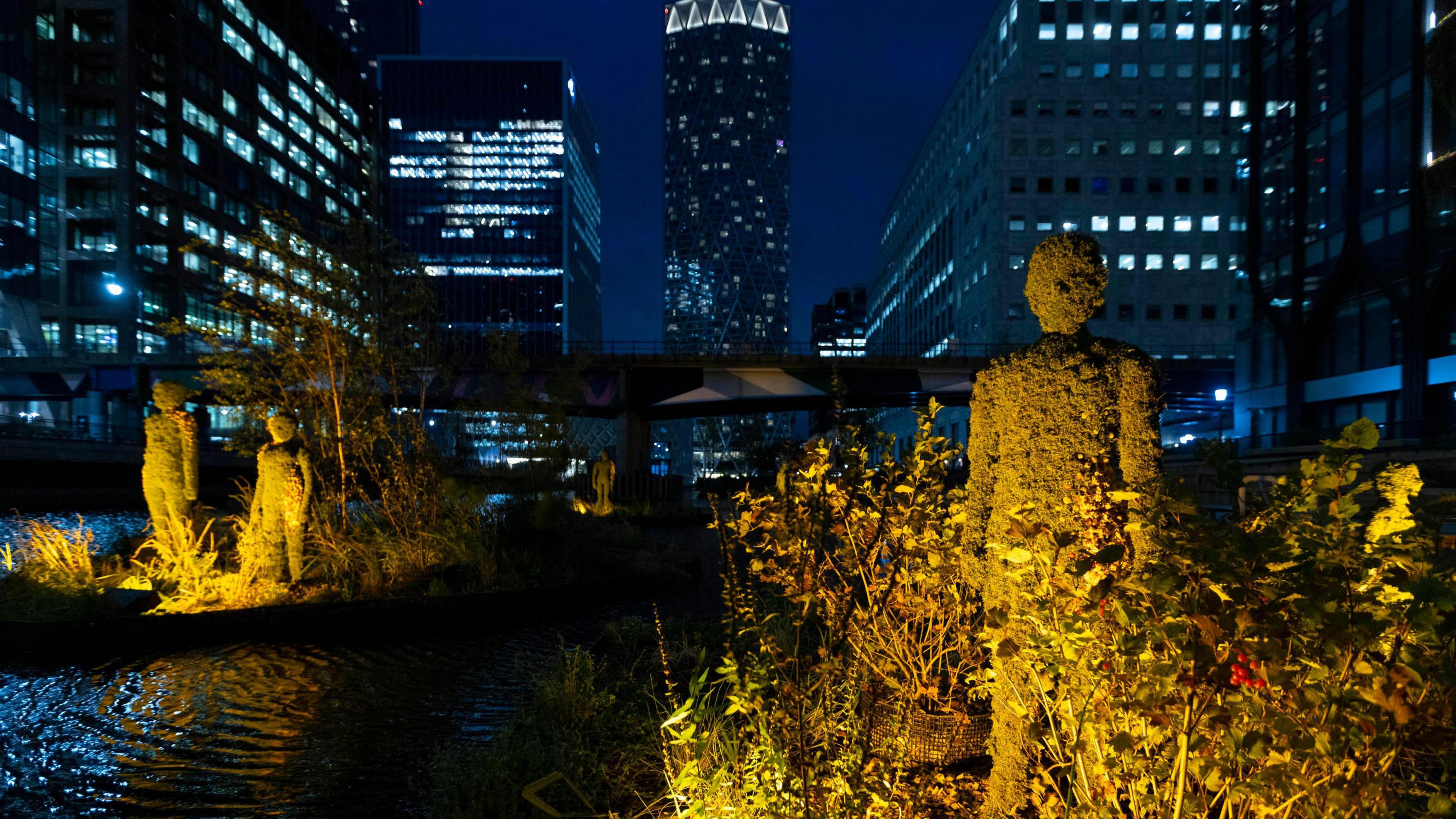 Large moss-covered statues on floating islands in the dock waters