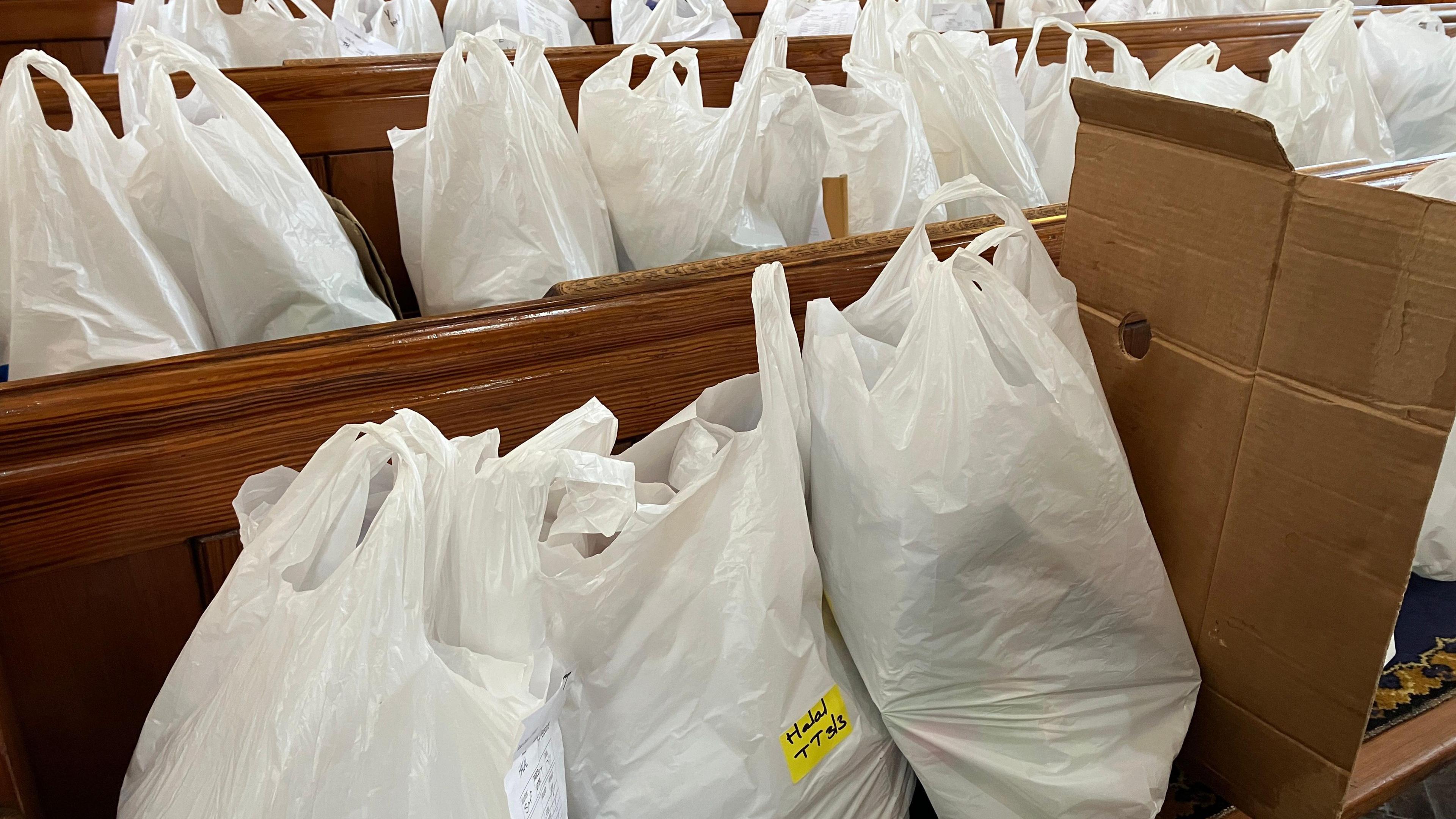 Dozens of food parcels on church benches.