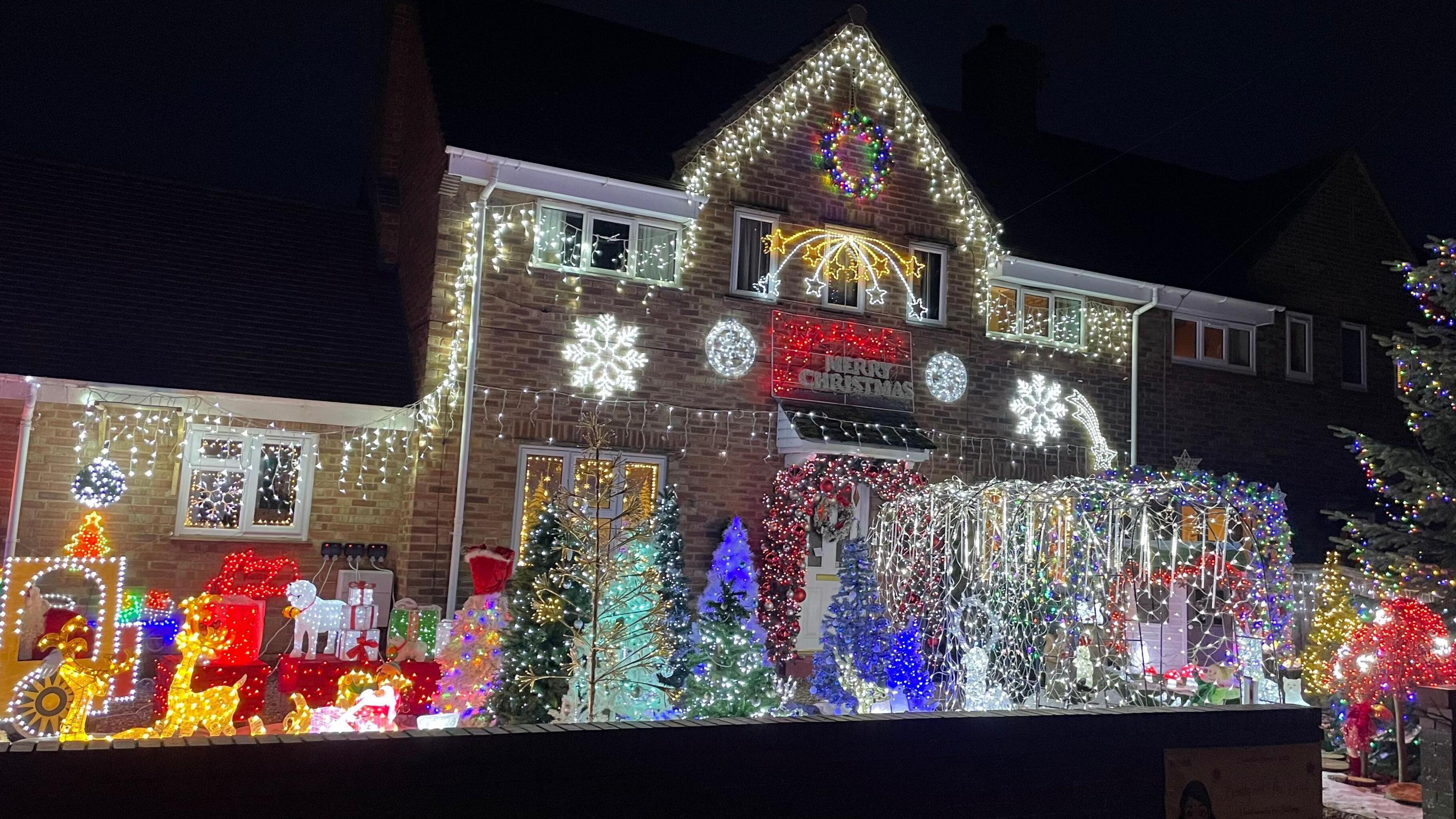 House and its gardens full of lights and festive characters.
