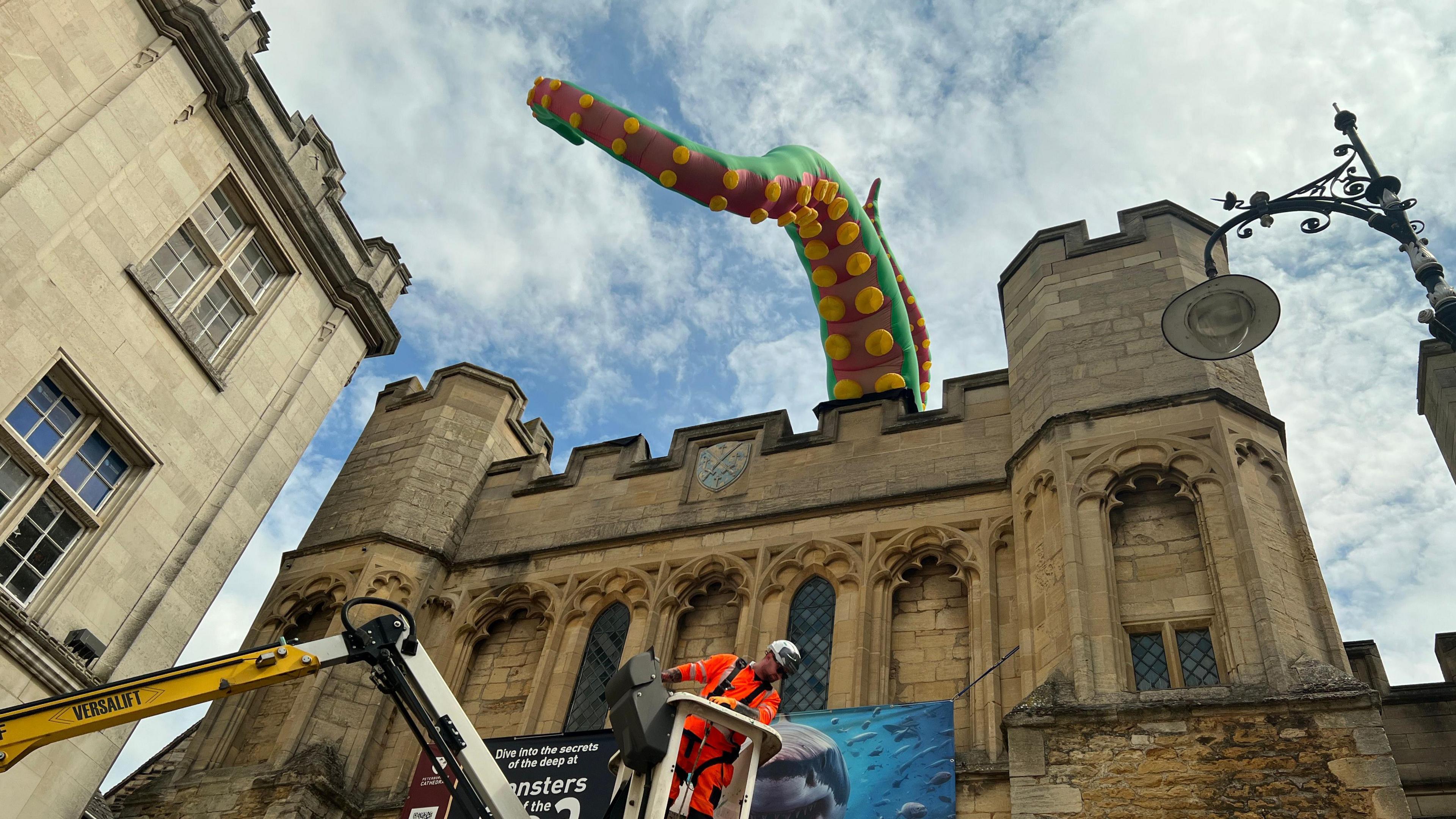 Ross Bowden of Peterborough Highway Services putting up an inflatable tentacle on the top of Peterborough Cathedral 