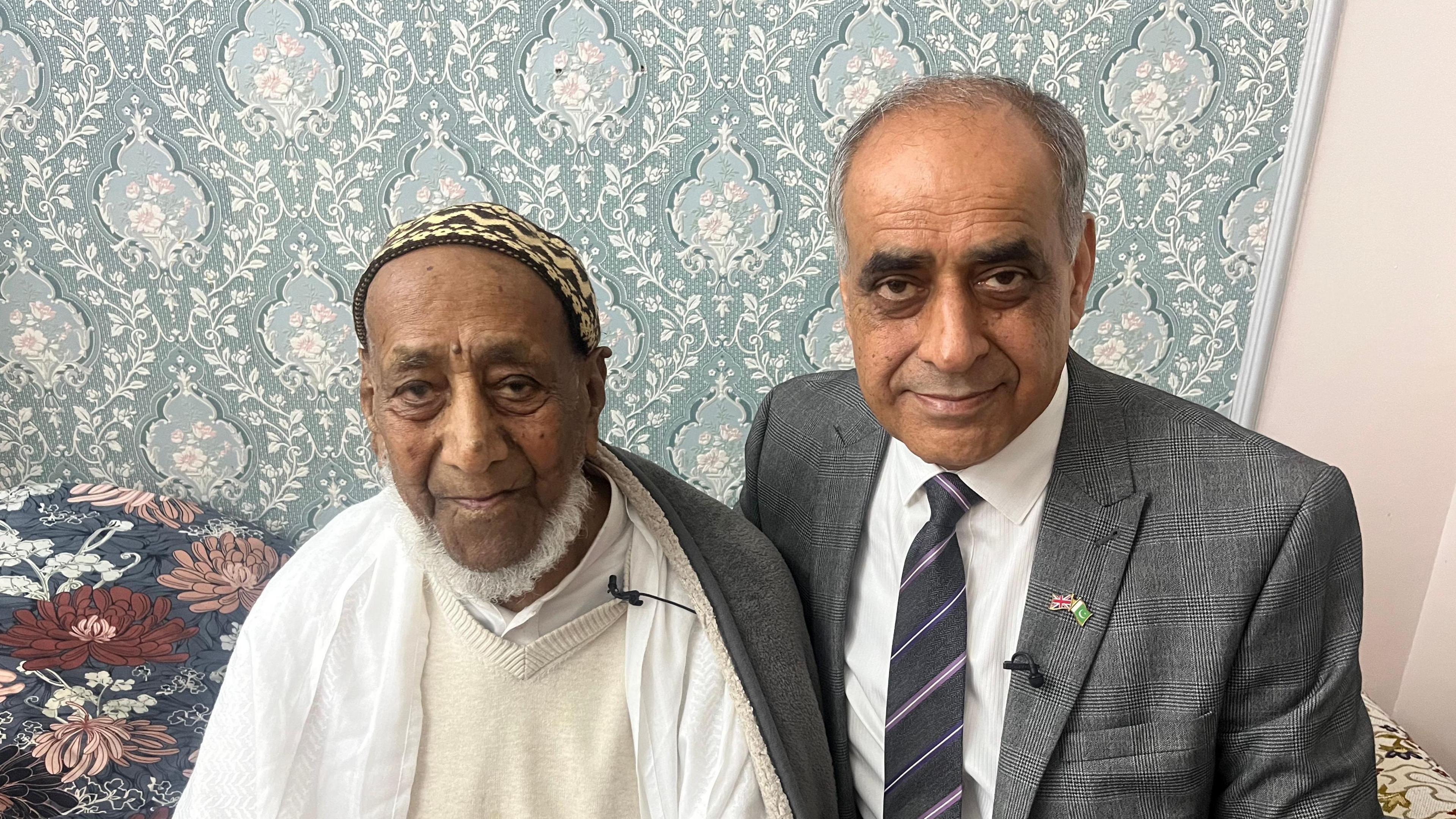 An elderly man sitting with his son