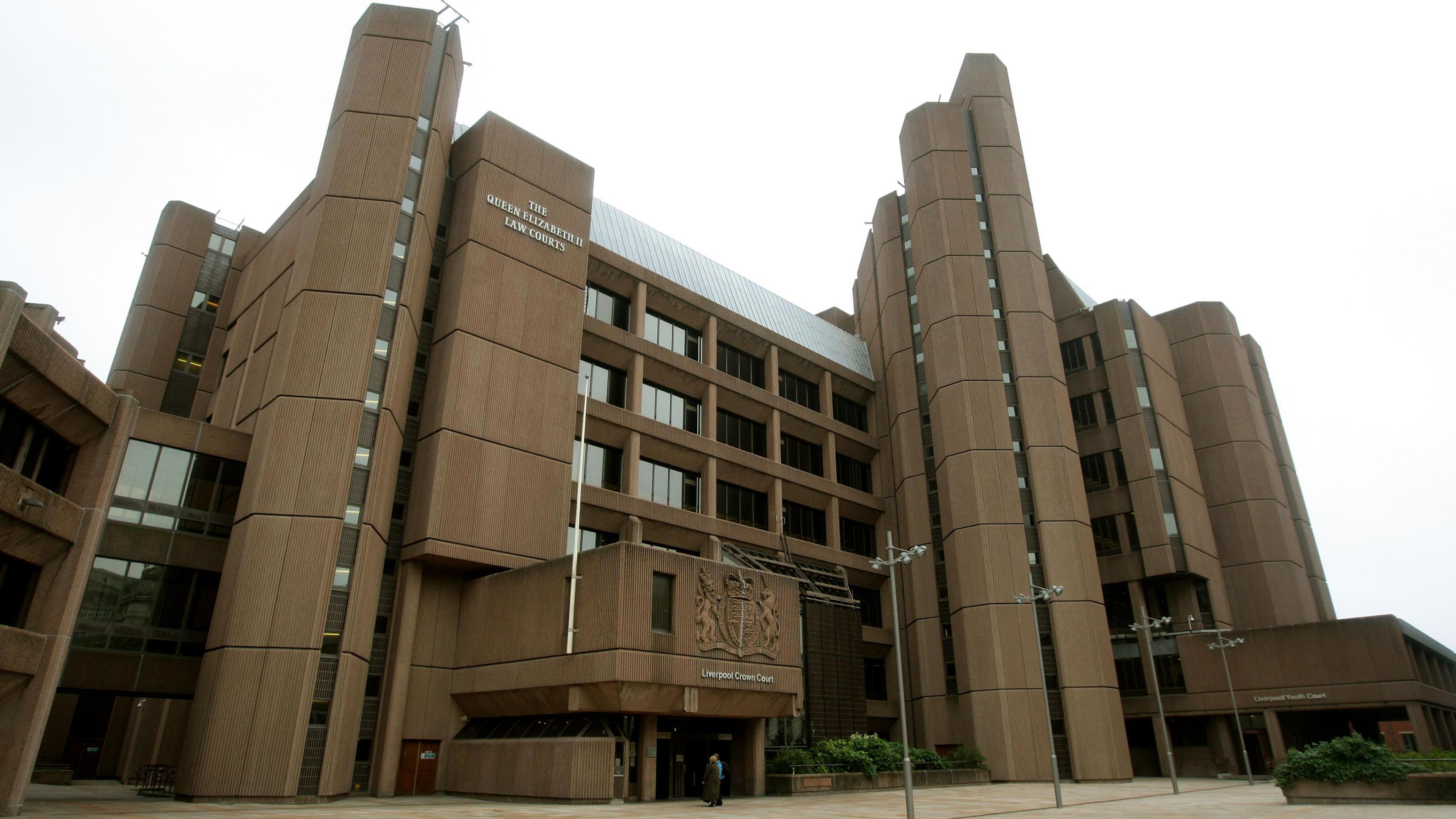 Liverpool Crown Court, which is a six storey building with brown concrete cladding and cylindrical structures at its corners