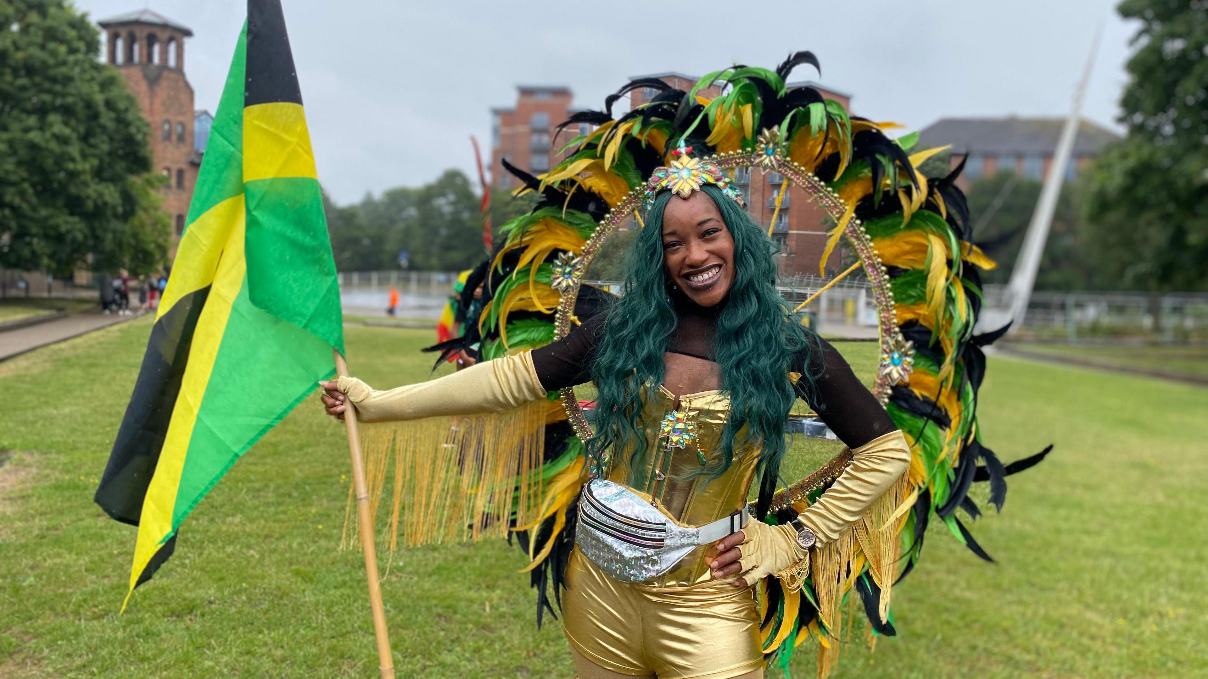 A woman in a Jamaican coloured outfit with a flag