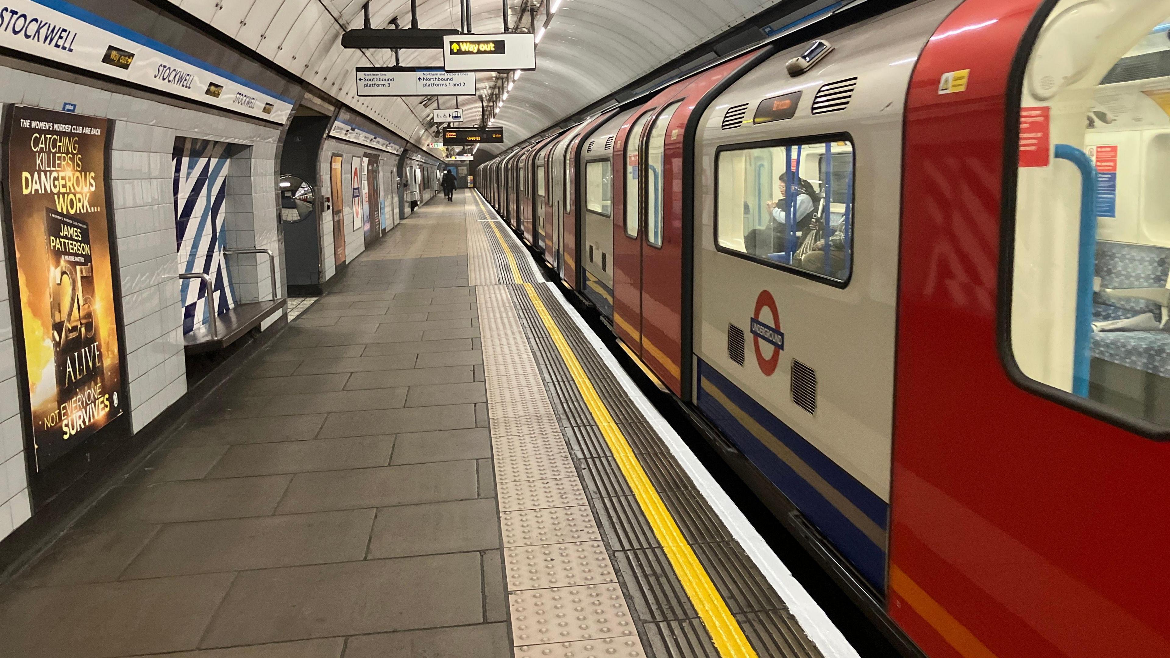 Red and white Tube train on platform at Stockwell station