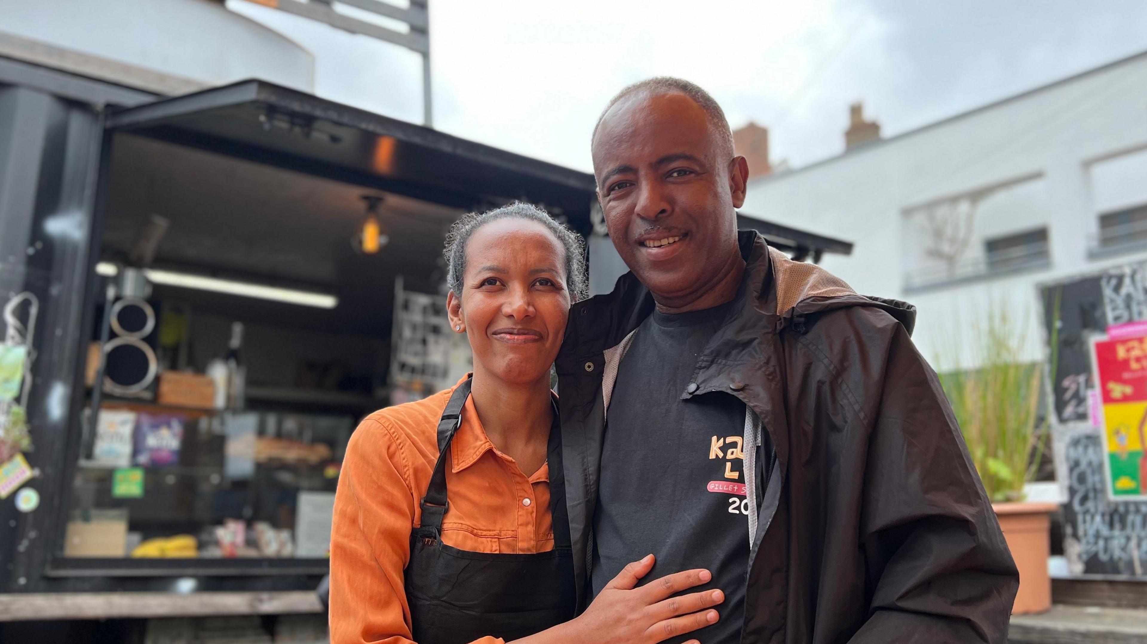 Yared Markos and Almaz Haile stand in front of the coffee shop